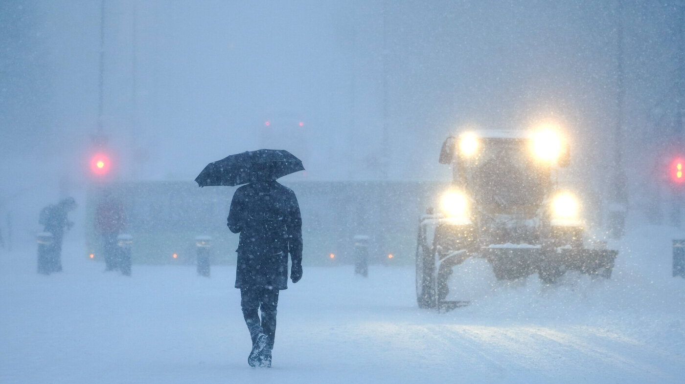 Bildet viser en mann og en brøytetraktor i et snøtett Oslo