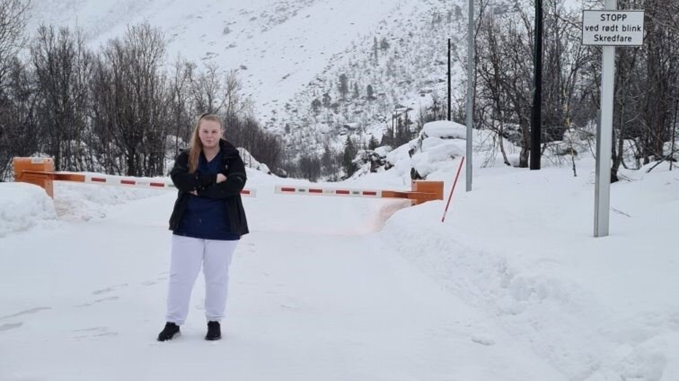 Bildet viser Henny Silkoset Hauan foran en stengt vei