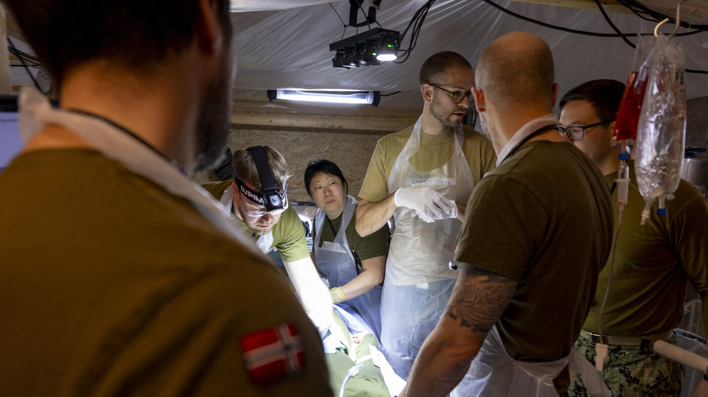 Bildet viser operasjonsteam på operasjonsstue i feltsykehus.