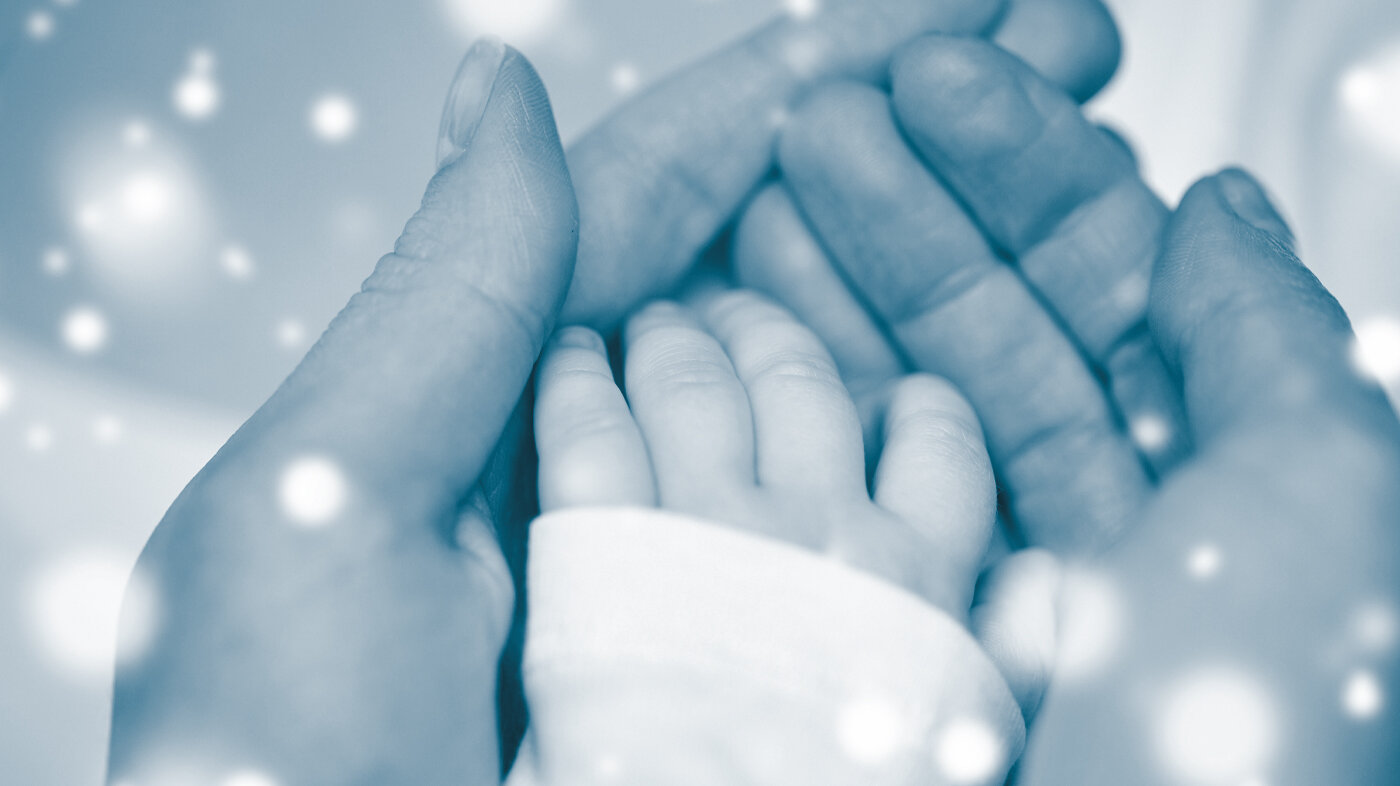 Baby's hand in mother's hands The picture shows a mother's hands holding around a small baby hand.