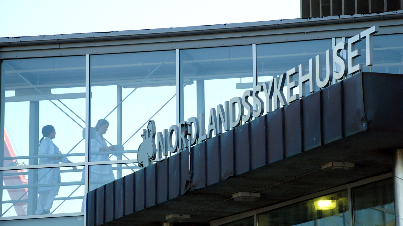 Bildet viser helsepersonell gjennom et vindu på Nordlandssykehuset