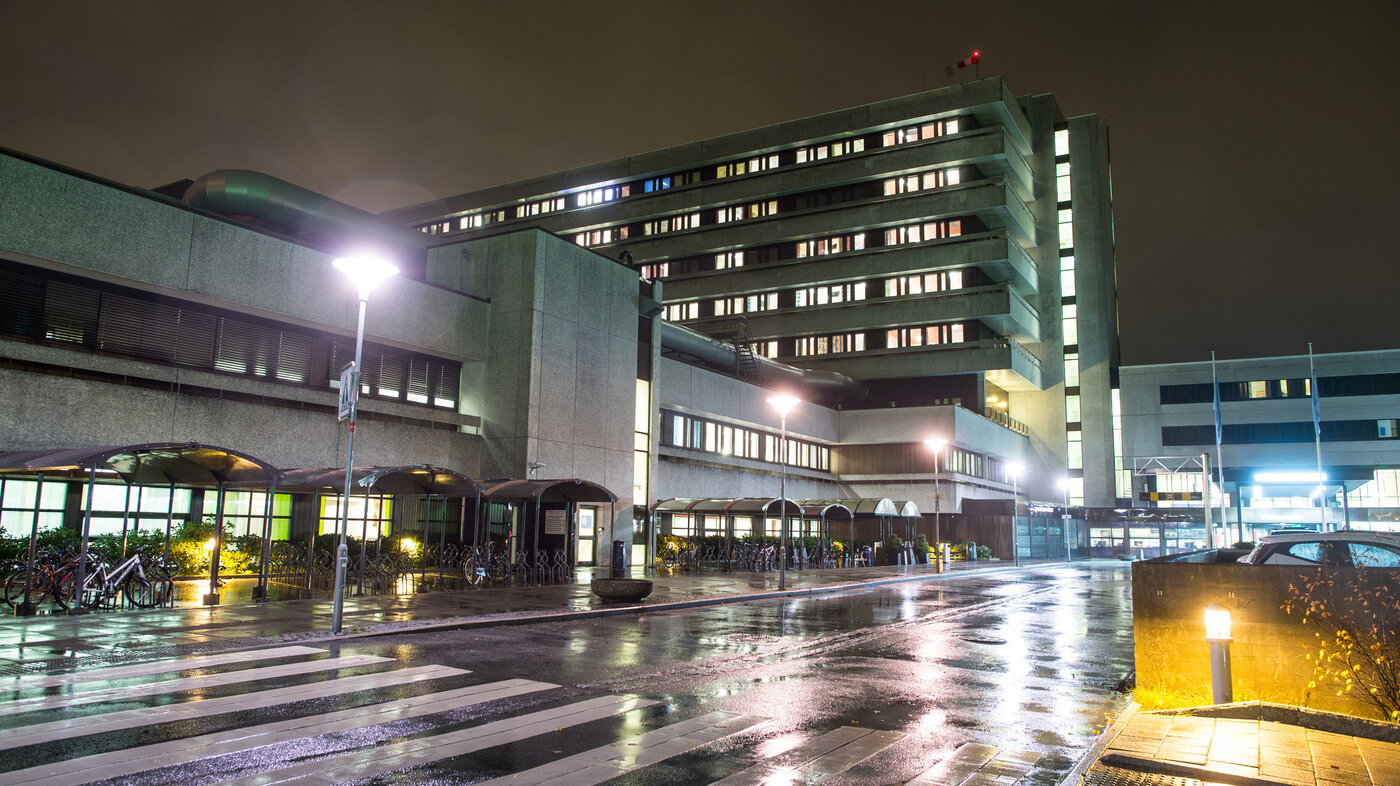 Bildet viser Stavanger universitetssjukehus (SUS) fra veistubben inn mot hovedinngangen i mørket.