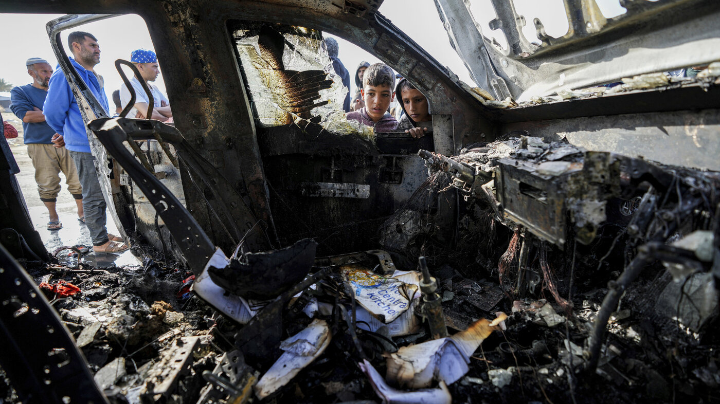 Palestinere kikker på en av bilene til World Central Kitchen (WCK) som ble rammet i et israelsk angrep.