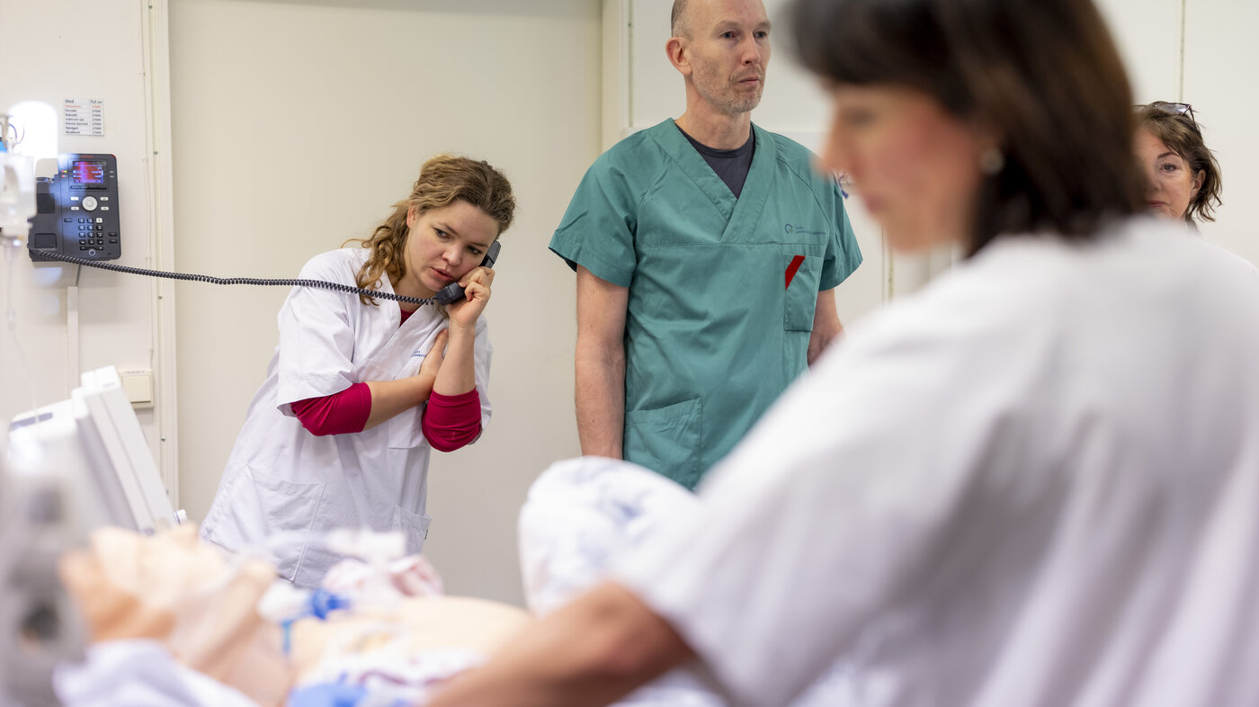 Bildet viser sykepleierstudenter og annet helsepersonell som simulerer pasientsituasjoner med bruk av en dokke.