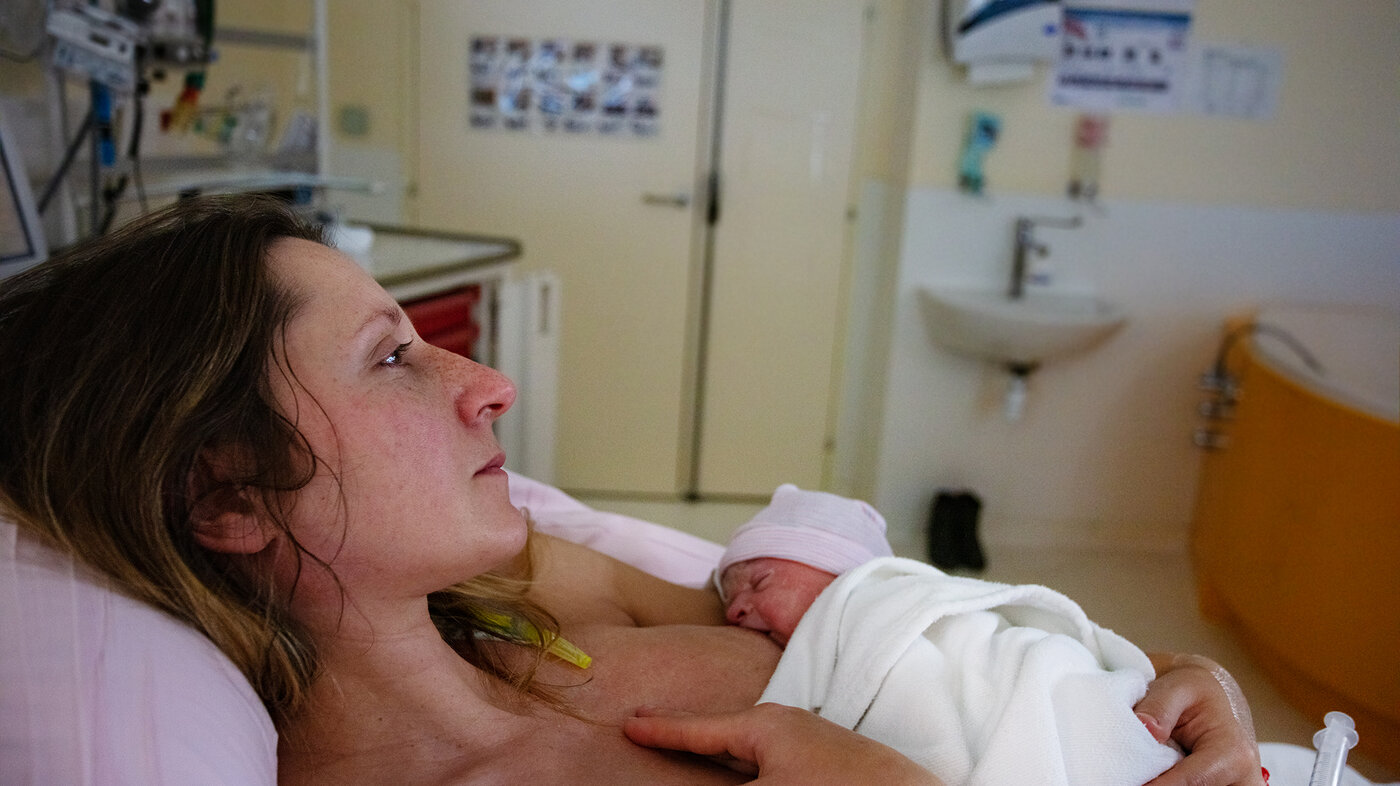 Bildet viser en kvinne som har nettopp har født, og som ligger med den nyfødte på brystet.