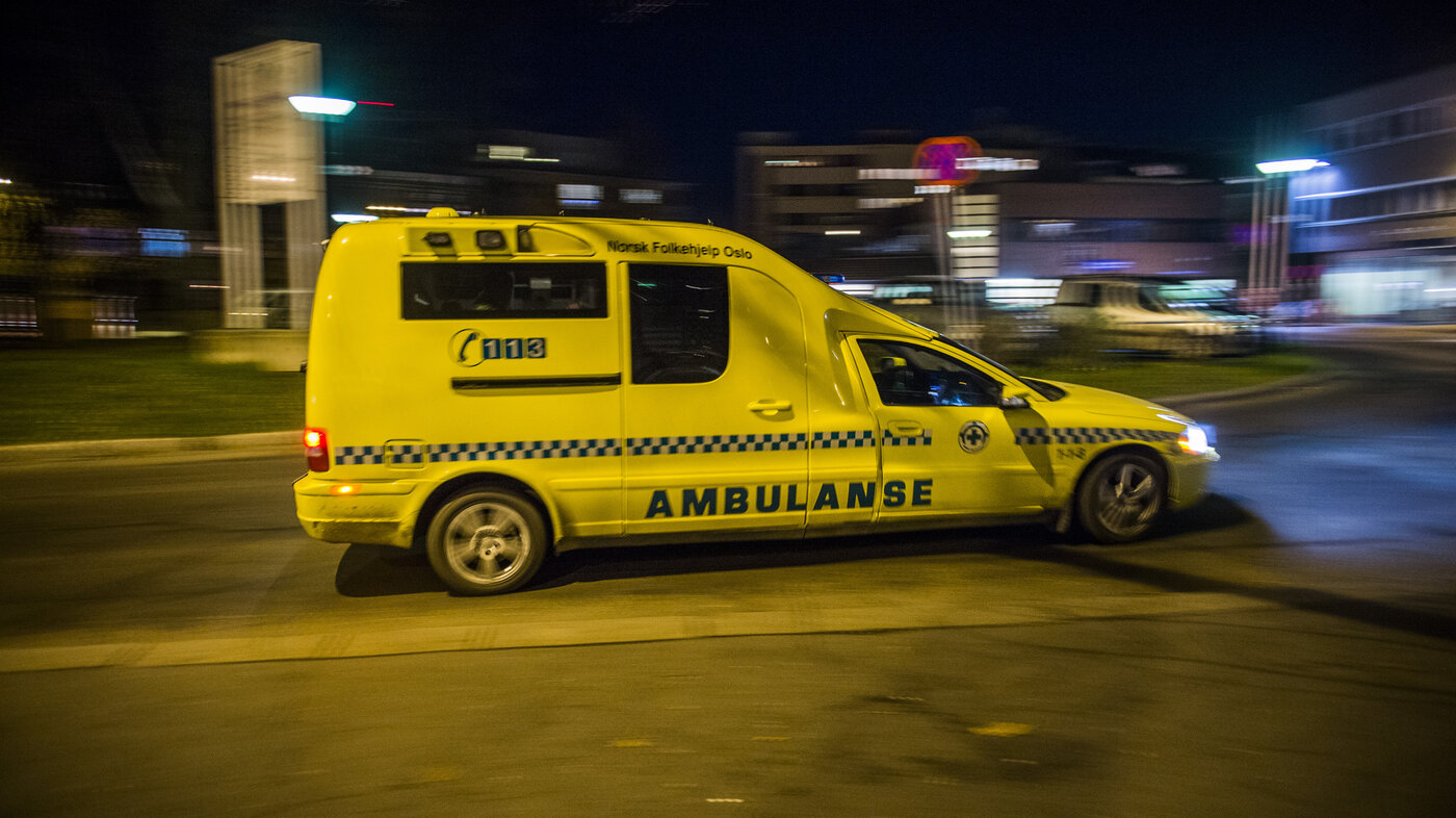 Bildet viser en ambulanse som kjører om kvelden