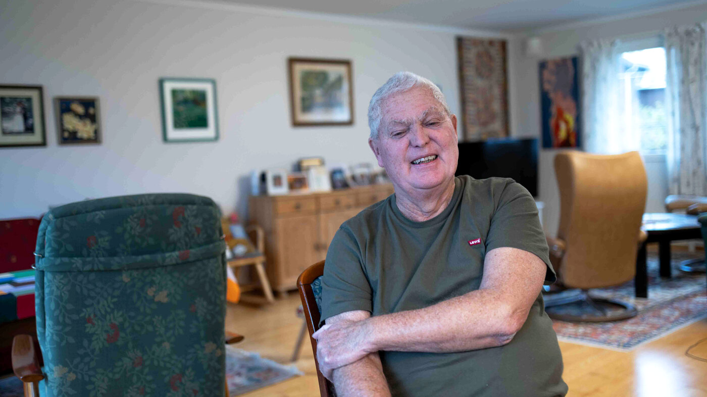 Bilde viser Leif Alnes med et smil, hjemme i stua