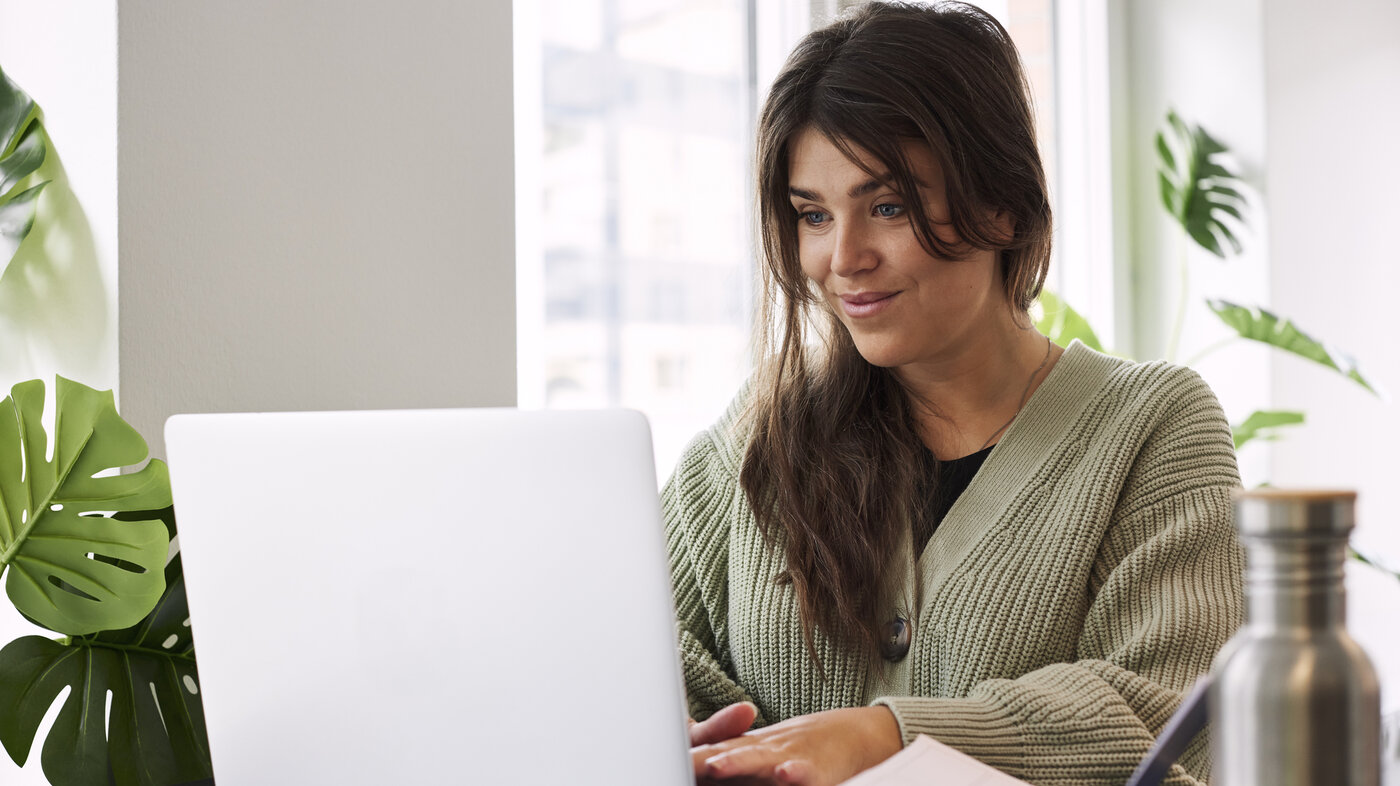 Bildet viser en student som sitter på laptopen sin hjemme