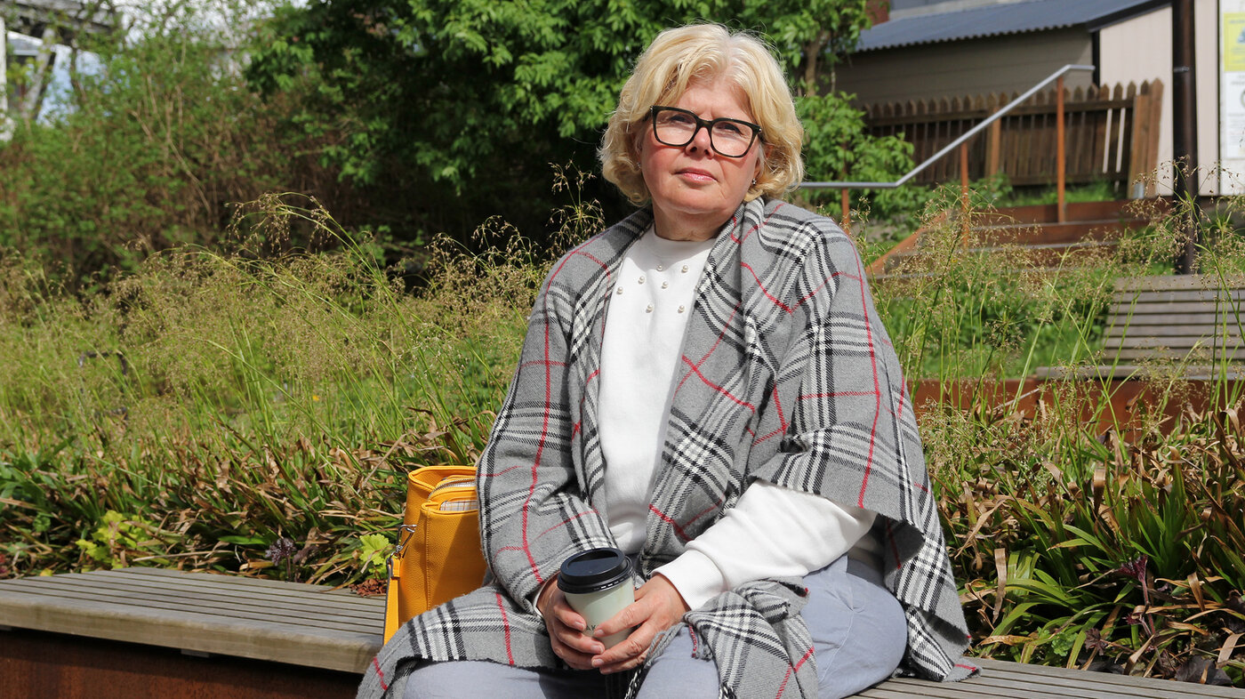 Bildet viser kreftoverleveren Ingunn Haugenes på en benk