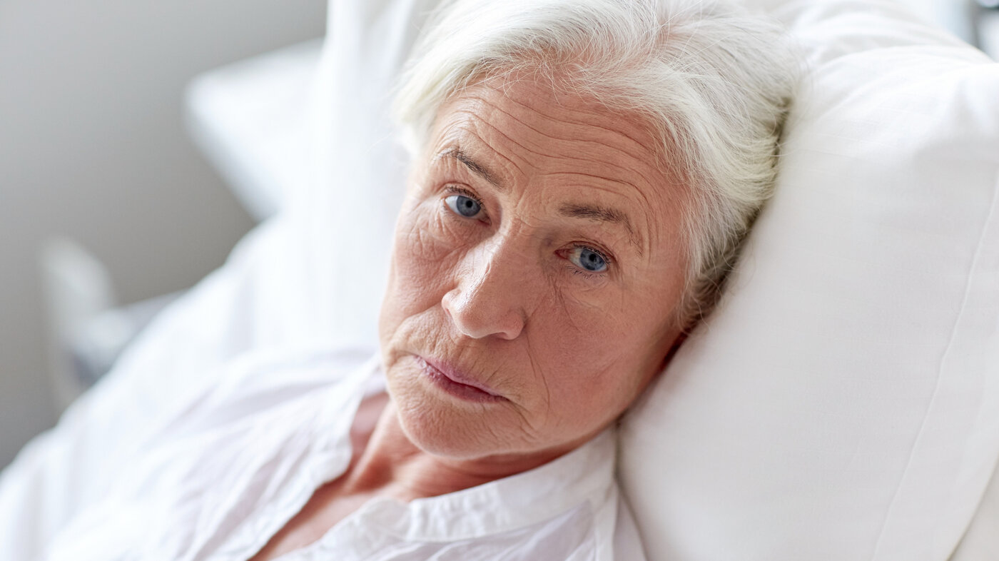 Bildet viser en trist eldre pasient med kreft