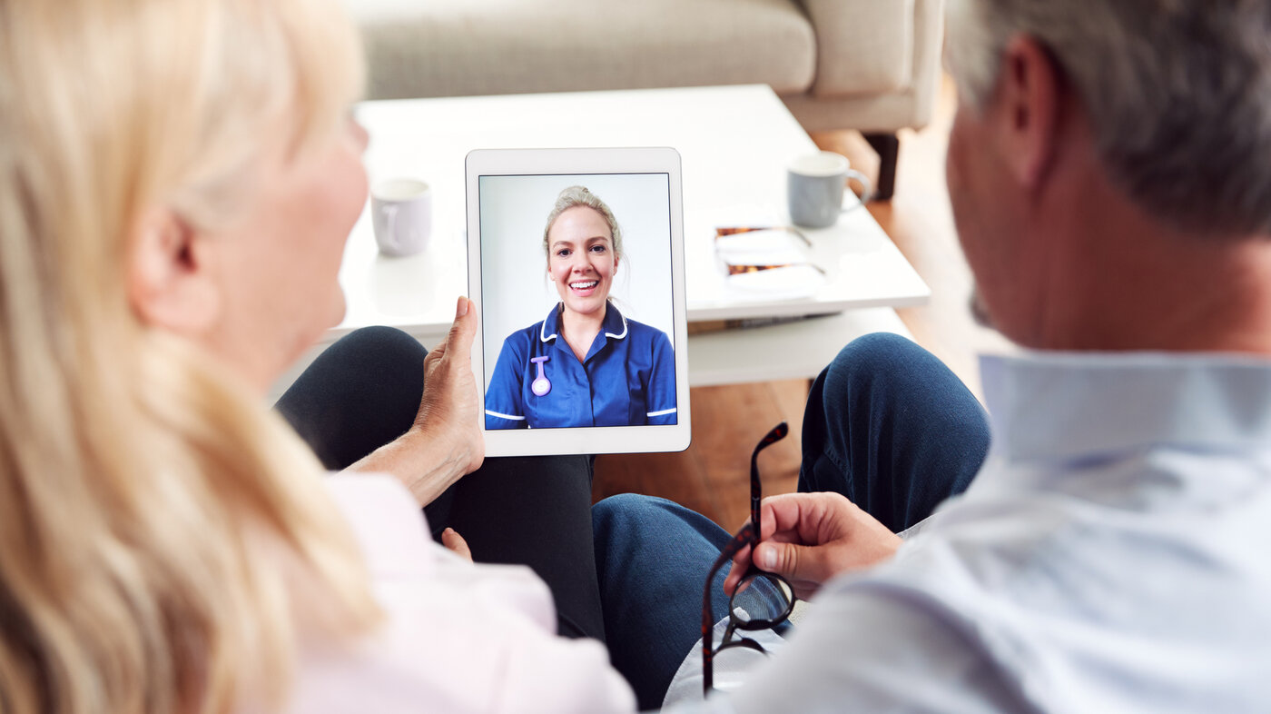 Bildet viser en sykepleier som har en digital videokonsultasjon med pasient og pårørende