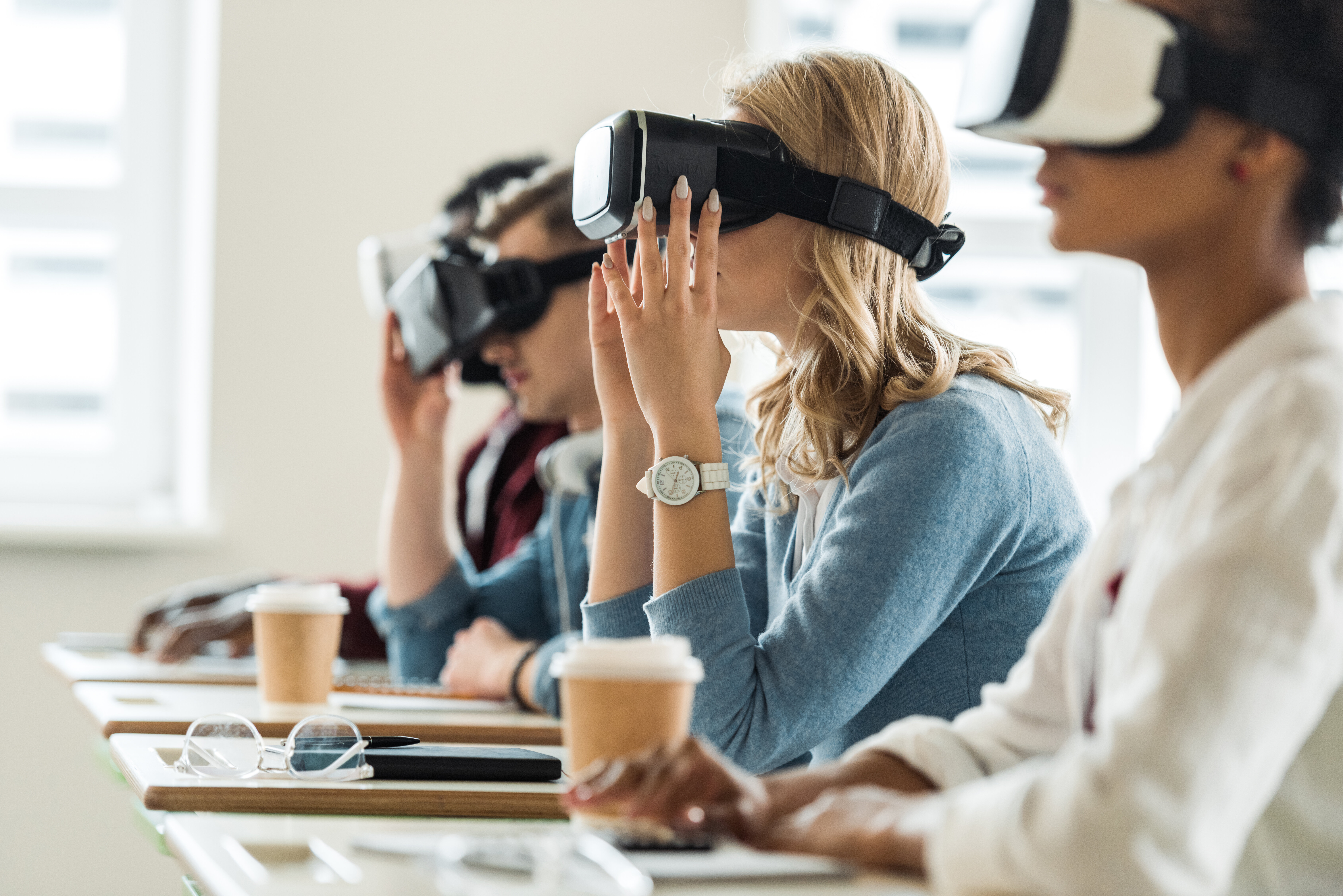 VR-teknologi i undervisningen Bildet viser studenter med VR-briller på. De sitter ved sine pulter i et klasserom