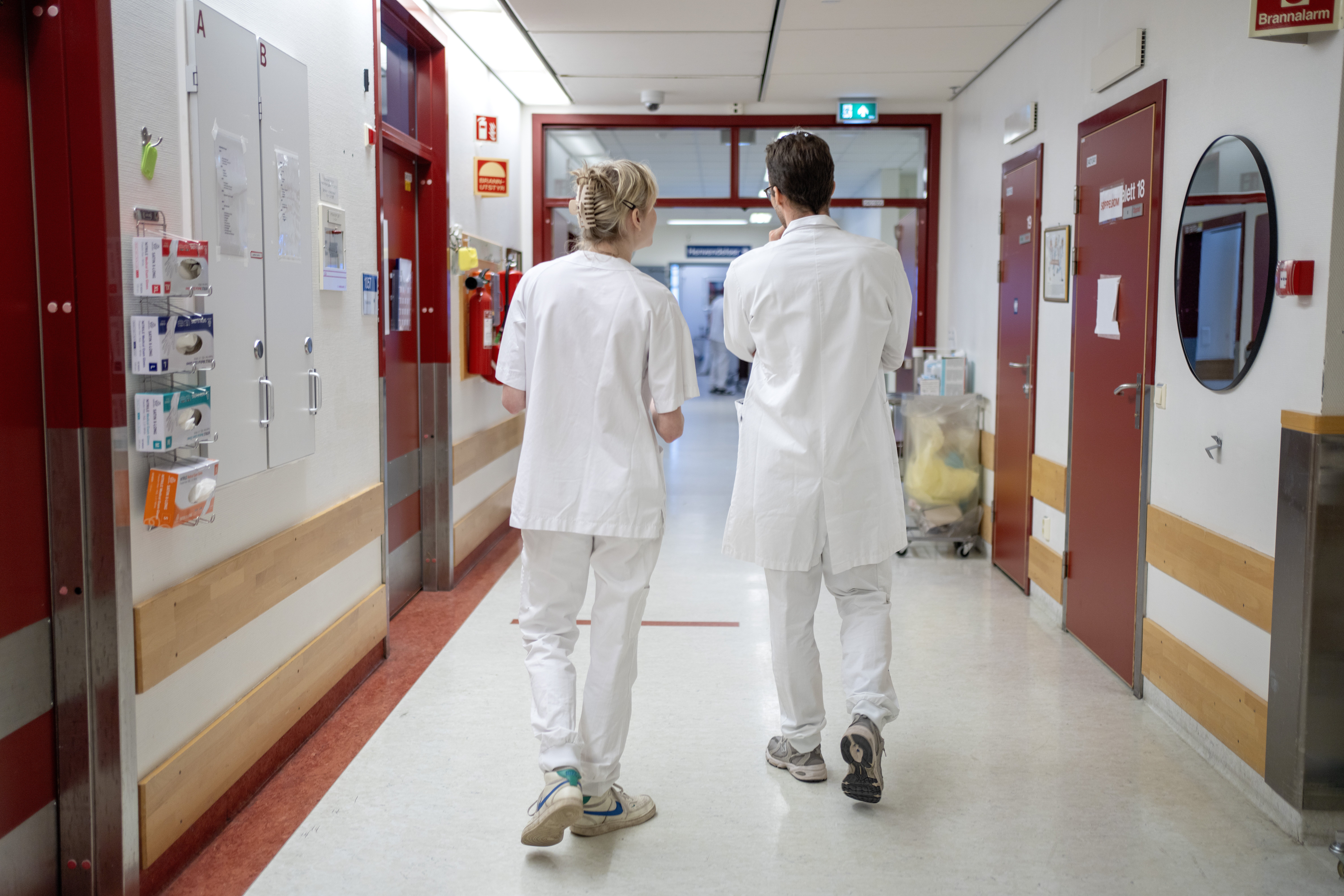 Bildet viser helsepersonell som går i en gang.
