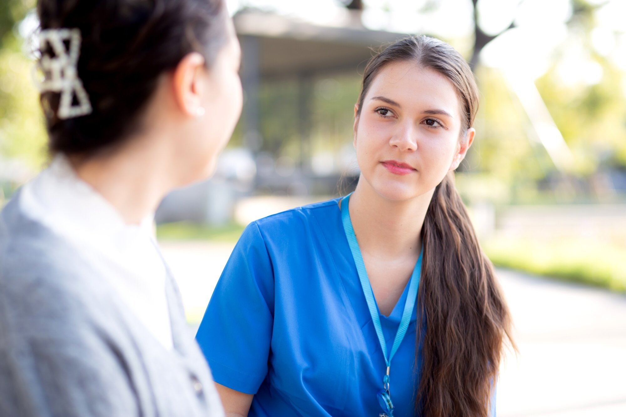 Bildet viser en sykepleier som har en alvorlig samtale med en pasient