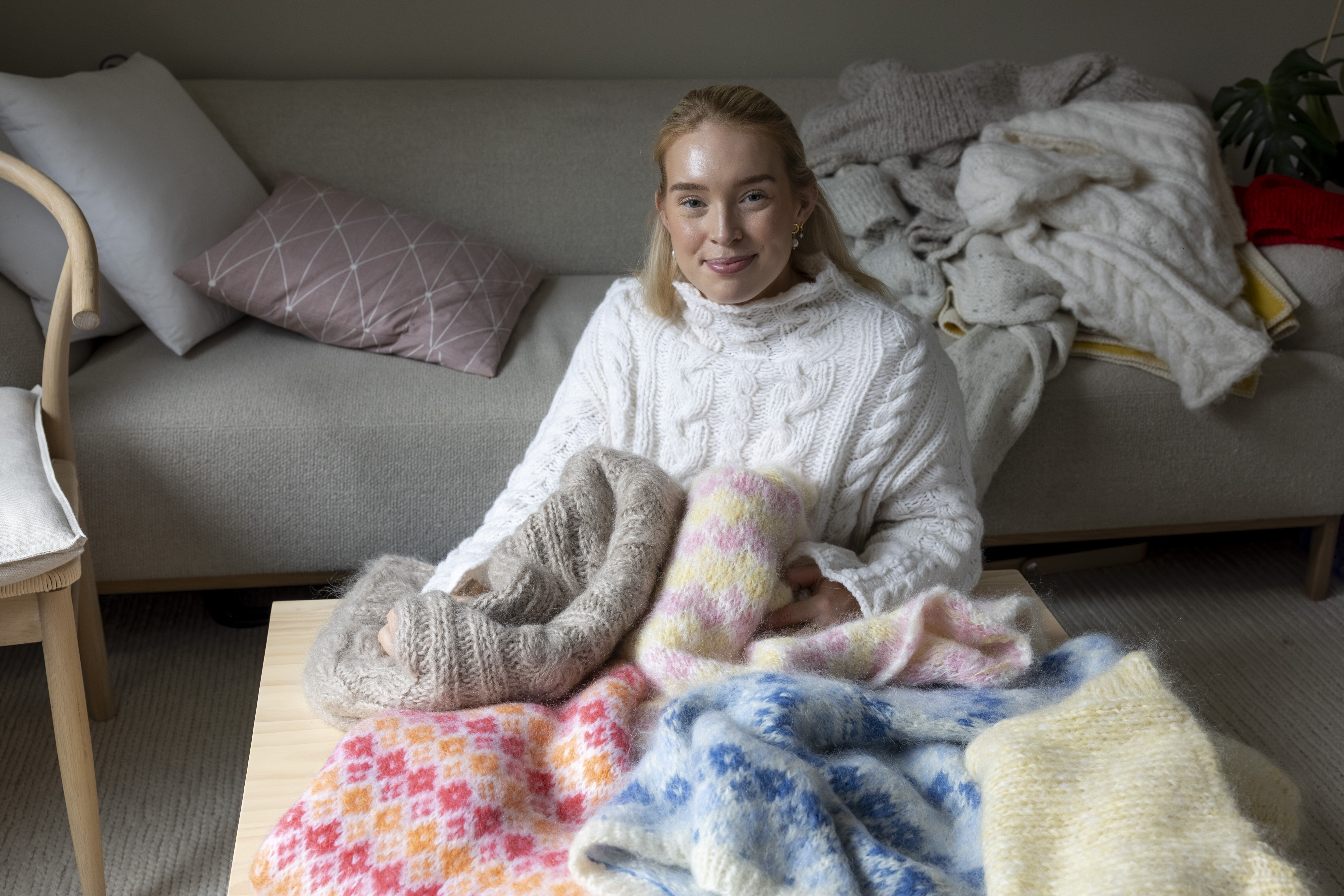 Bildet viser Maria Tessem med flere ulike gensere.