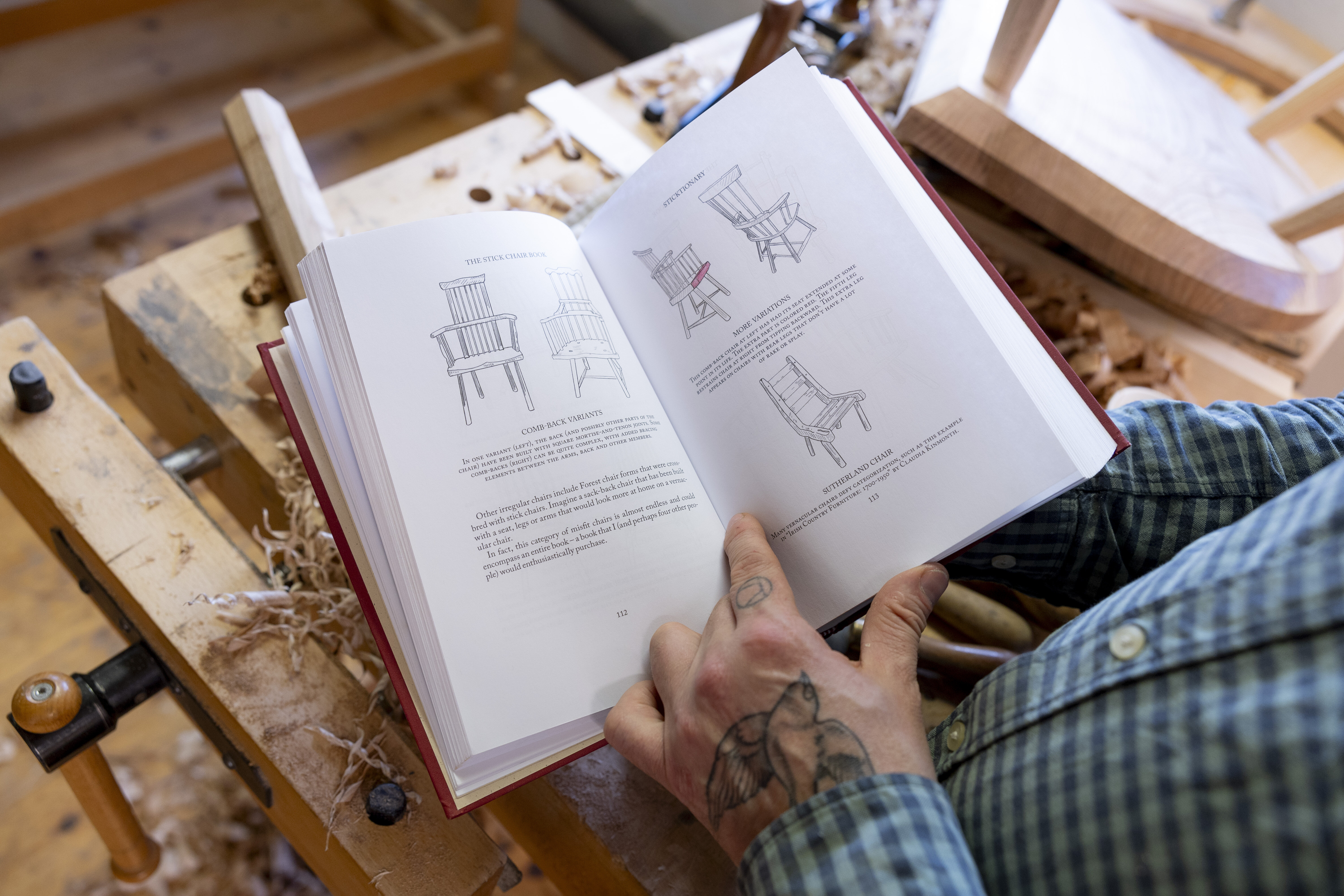 Bildet viser Klaus Skrudland som blar i en bok om stoler.