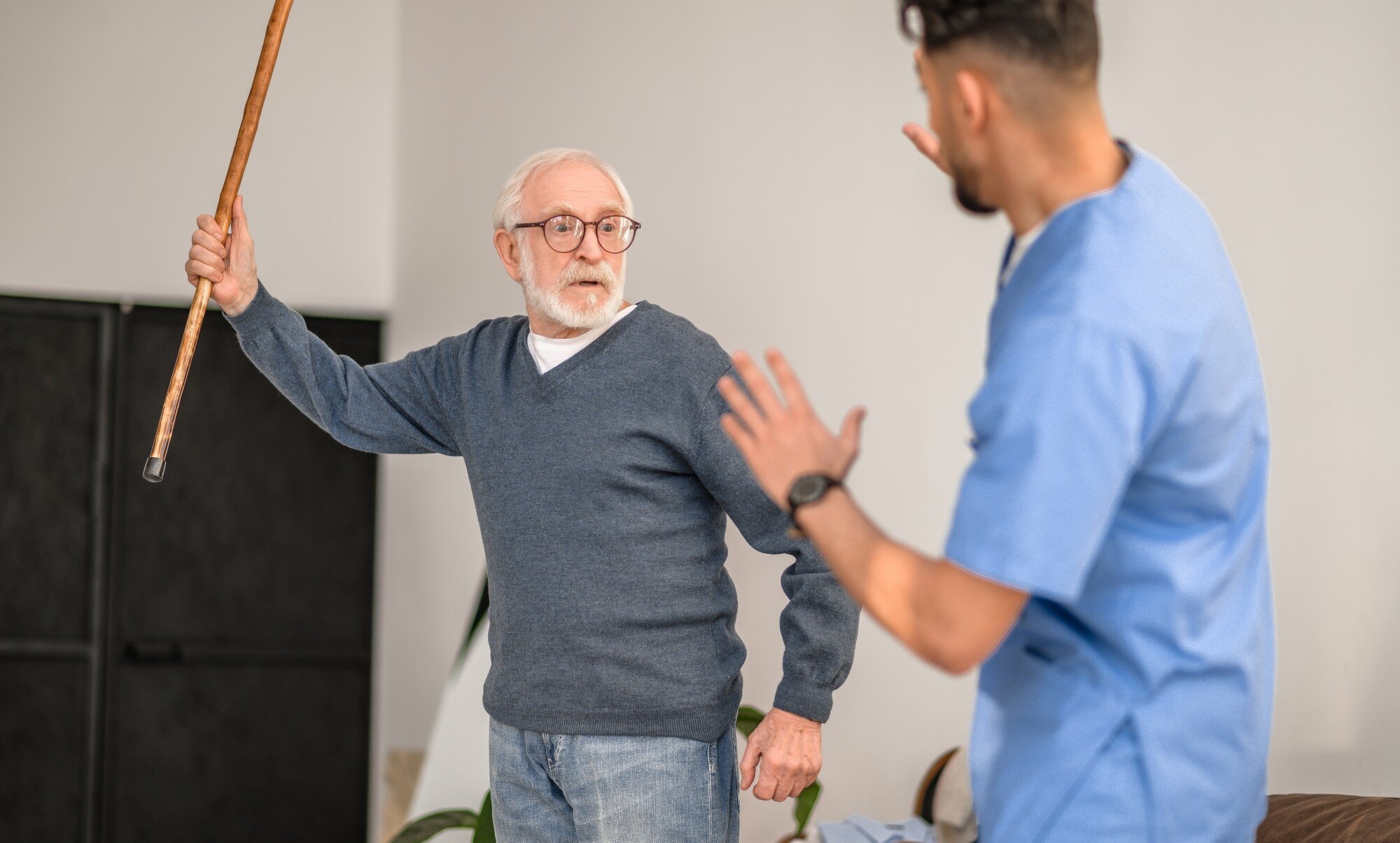 Bildet viser en aggressiv pasient som prøver å slå en sykepleier