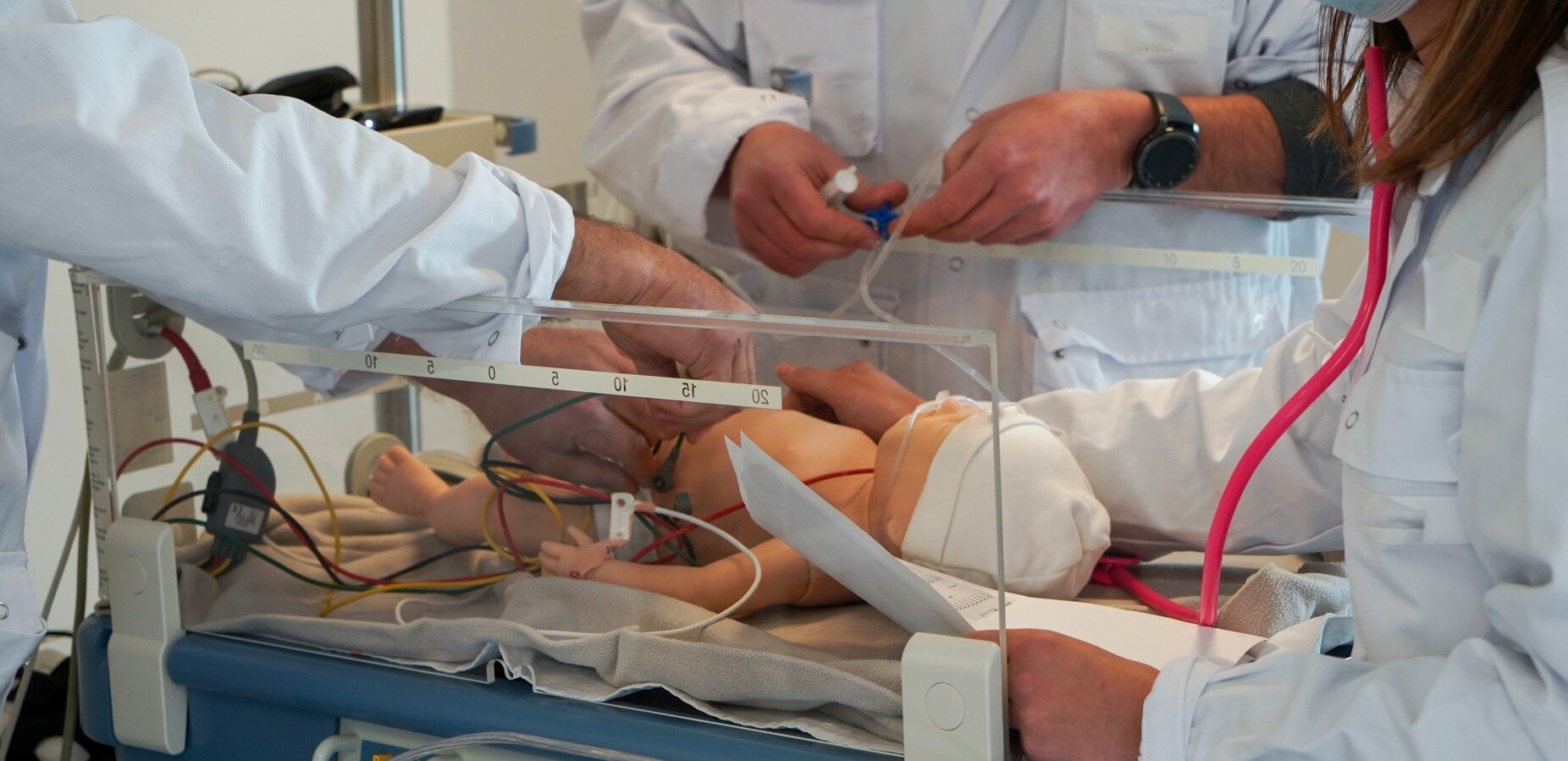 Bildet viser masterstudenter i barnesykepleie som simulerer på en dukke