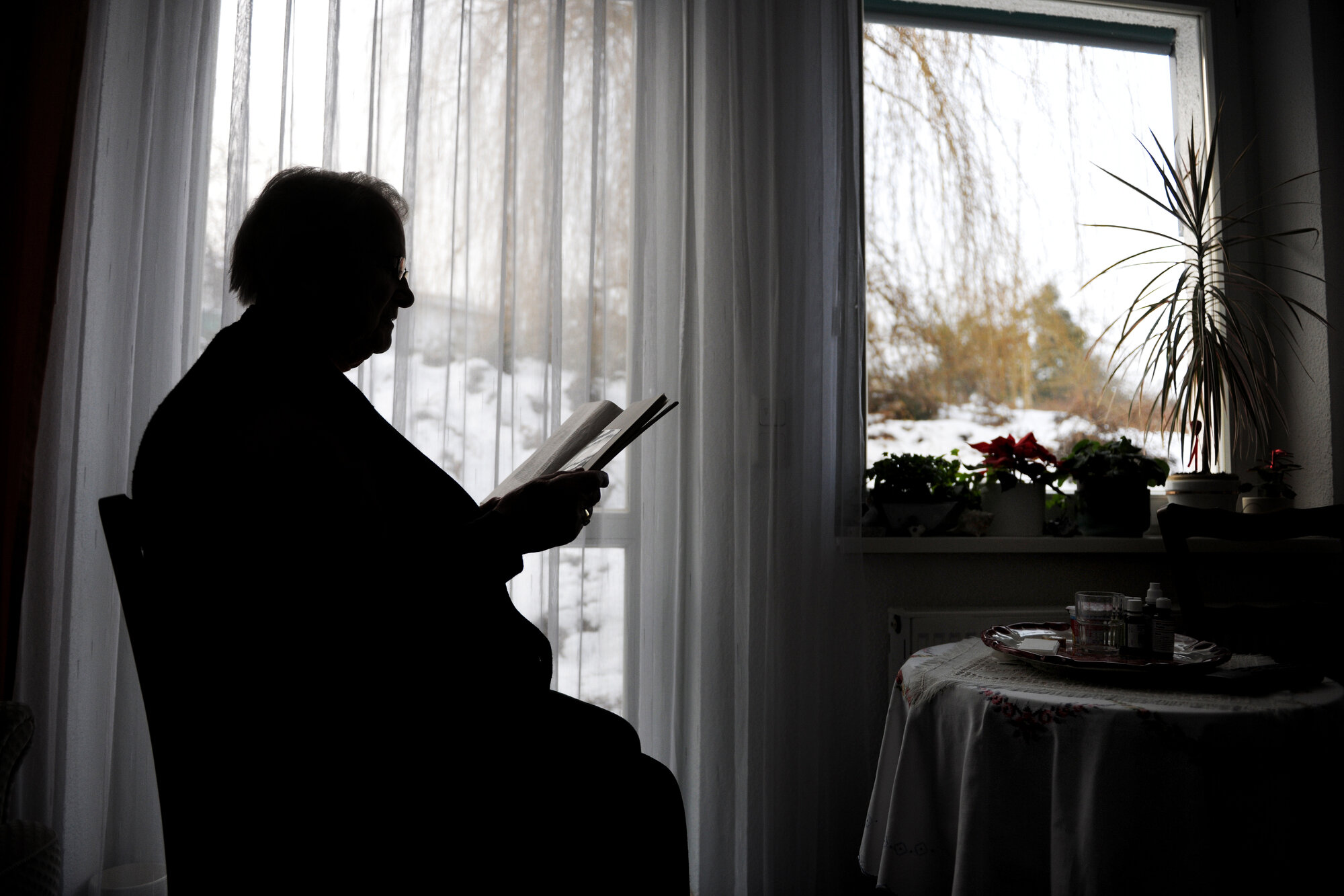 Bilde av eldre person ved kjøkkenbordet