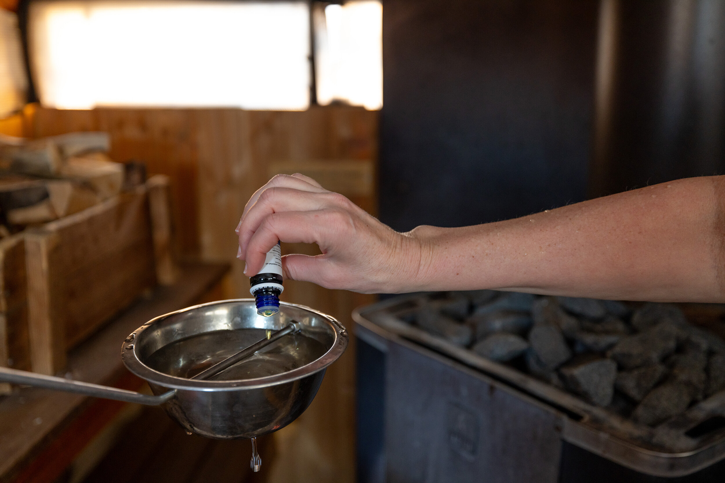 Bilde viser etteriskolje som helles i en badstue-skje.