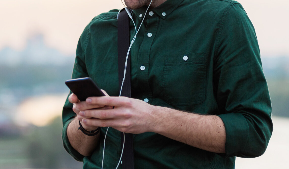 Bildet viser en mann som leser på mobilen.