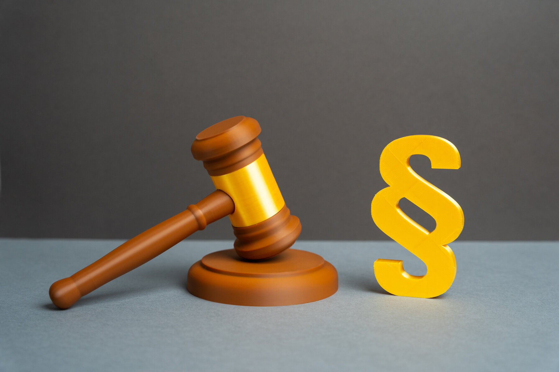 Bildet viser en dommerklubbe og en paragraf