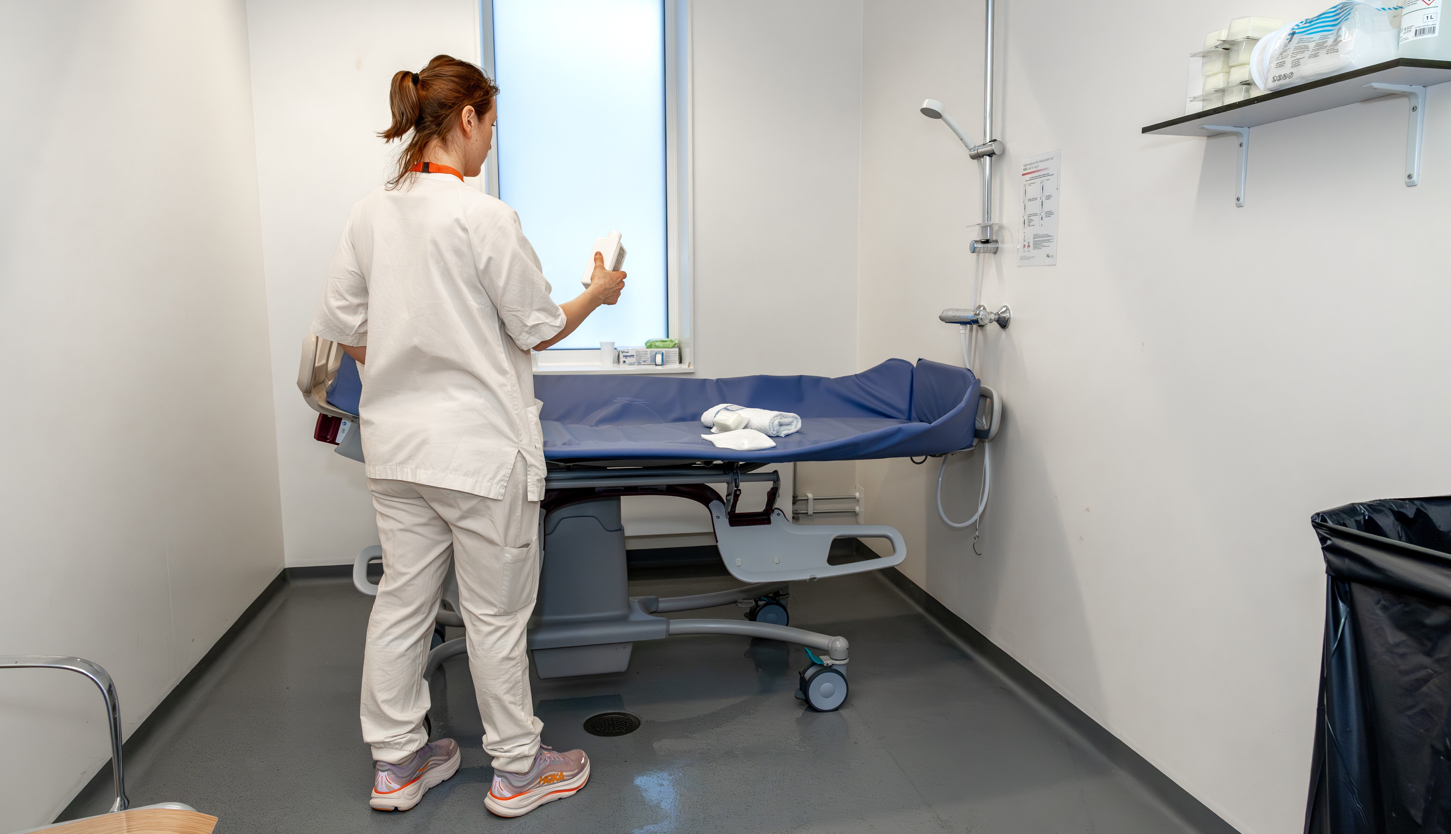 Bildet viser en sykepleier som skal utføre en preoperativ dusj 