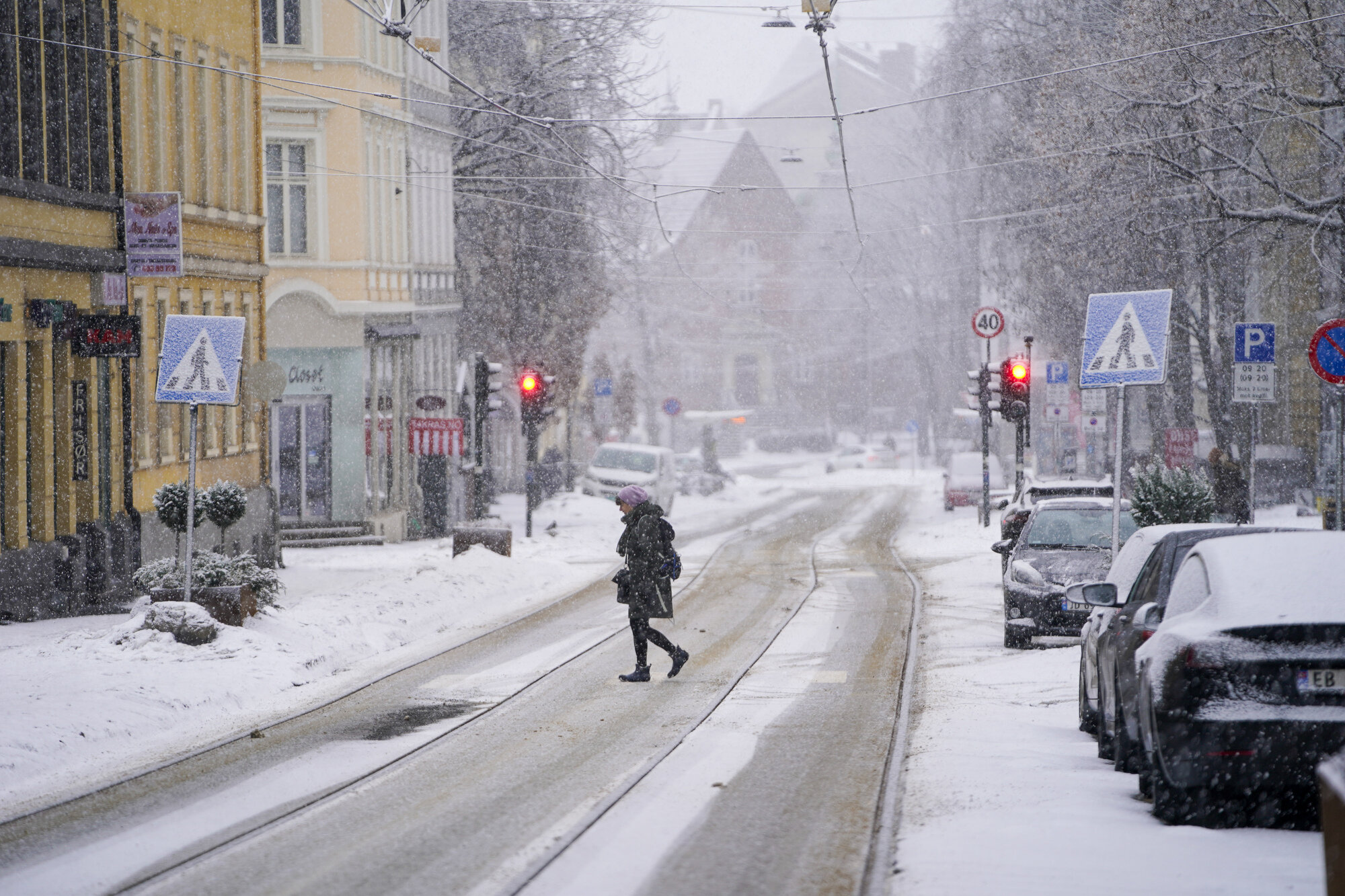 Bildet viser en kvinne som går i snøvær.