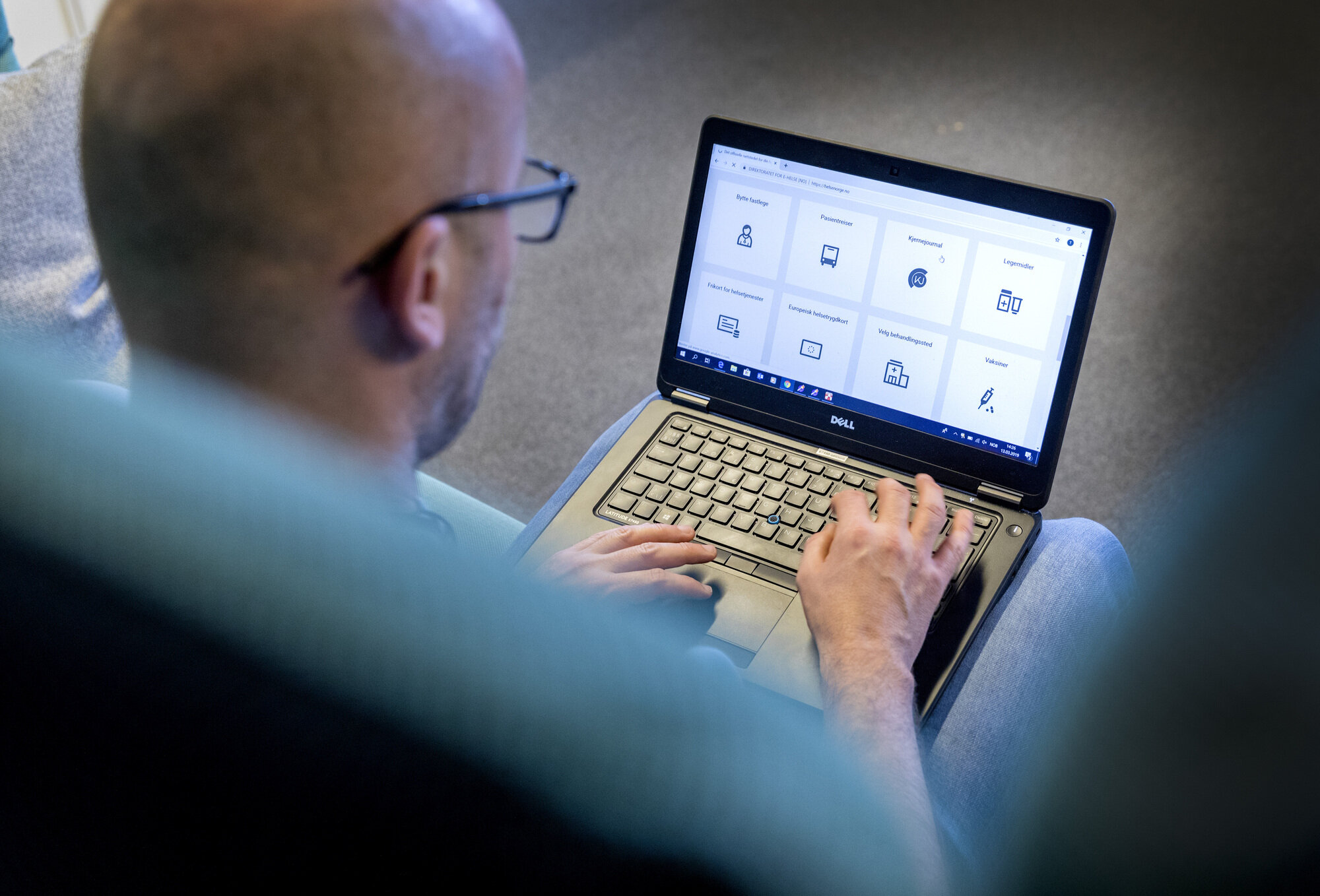 Bildet viser en mann som sitter med PC-en på fanget.