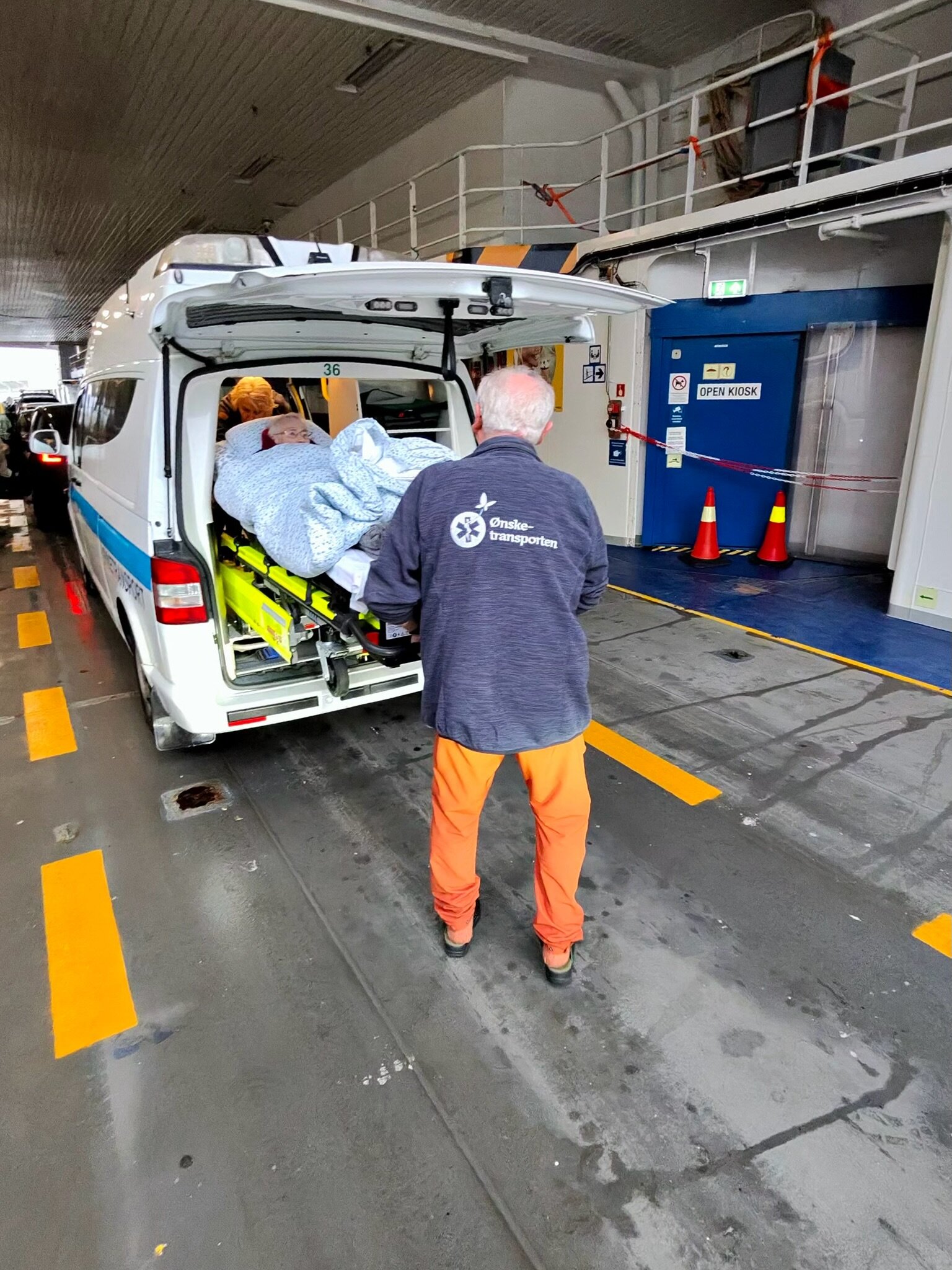 bildet av ansgar Fuglestad som hjelper Marta ut av ambulansen på fergen