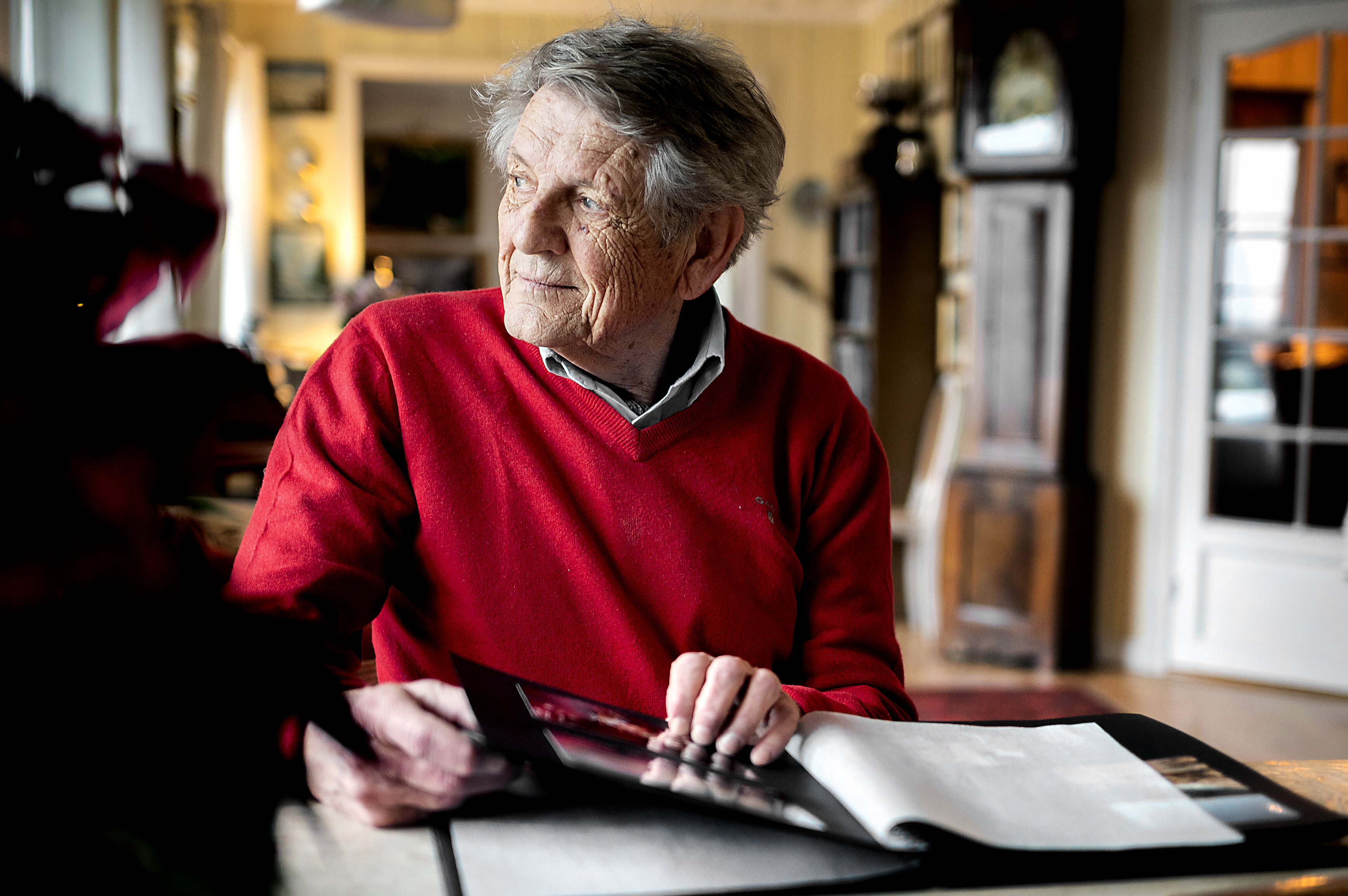 Bildet viser Jan-Erik Sverre som ser i fotoalbum.