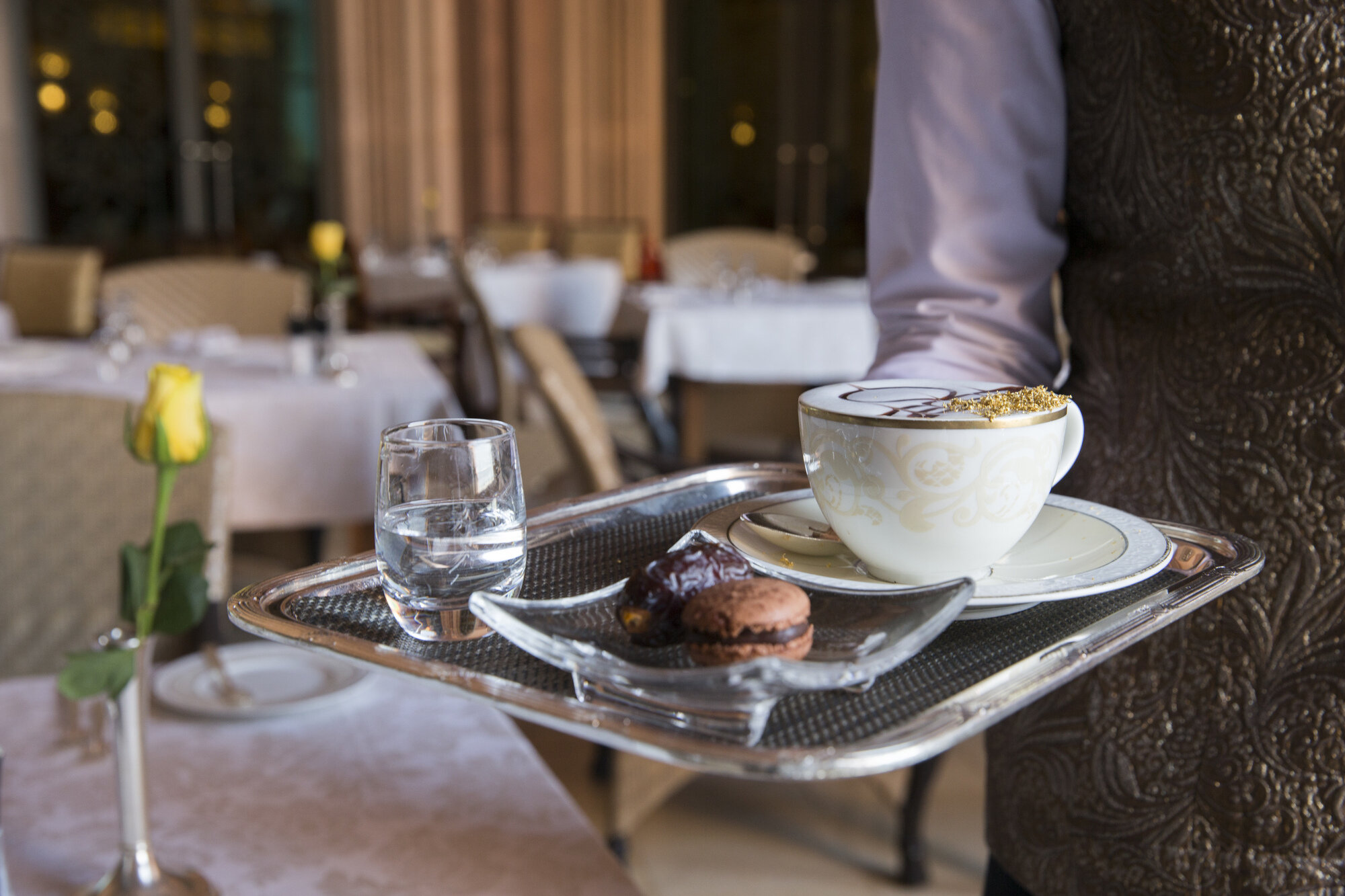 Bildet viser en servitør som serverer kaffe.