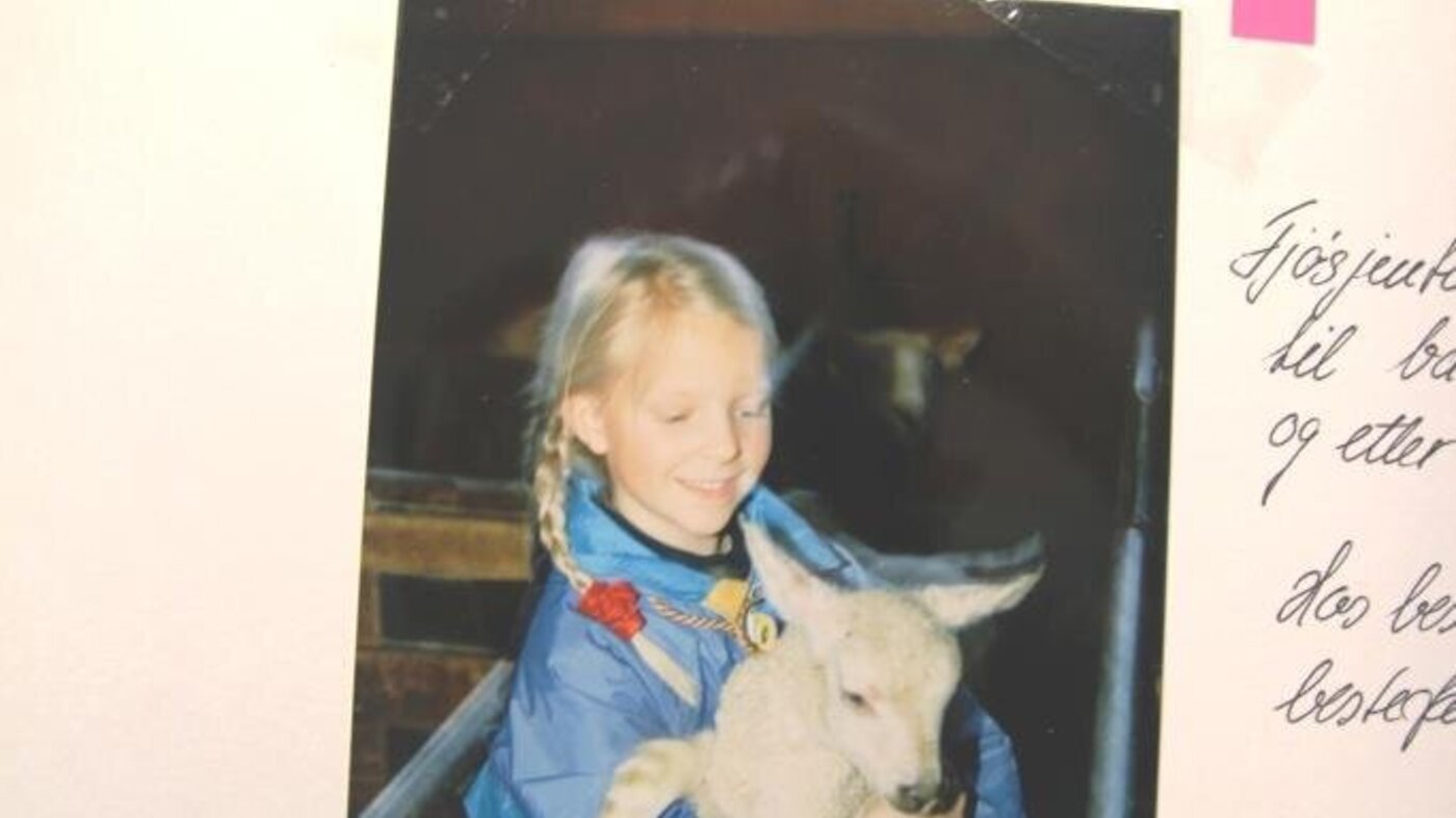 Bildet viser Frøya Marie Vinjar Eid som barn mens hun holder et lam.