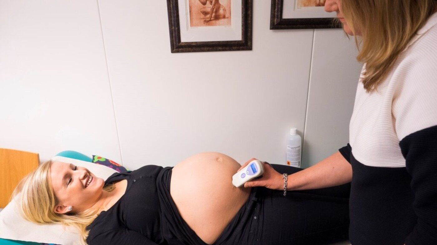Bildet viser jordmor Eva Myhre Engen som sjekker hjertelyden til Marte-Kari Løves baby.