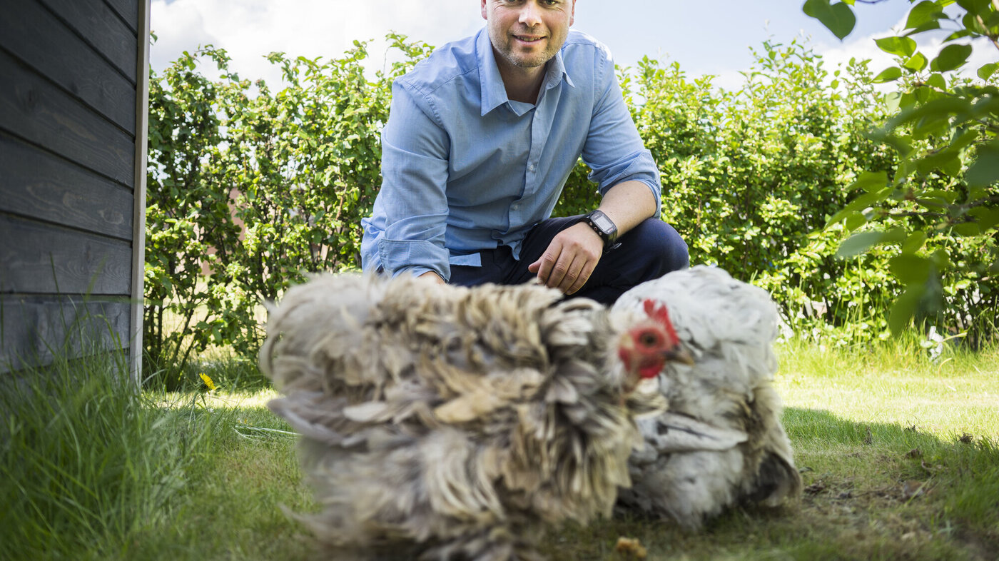 Bildet viser Martin Ytreland som mater høner