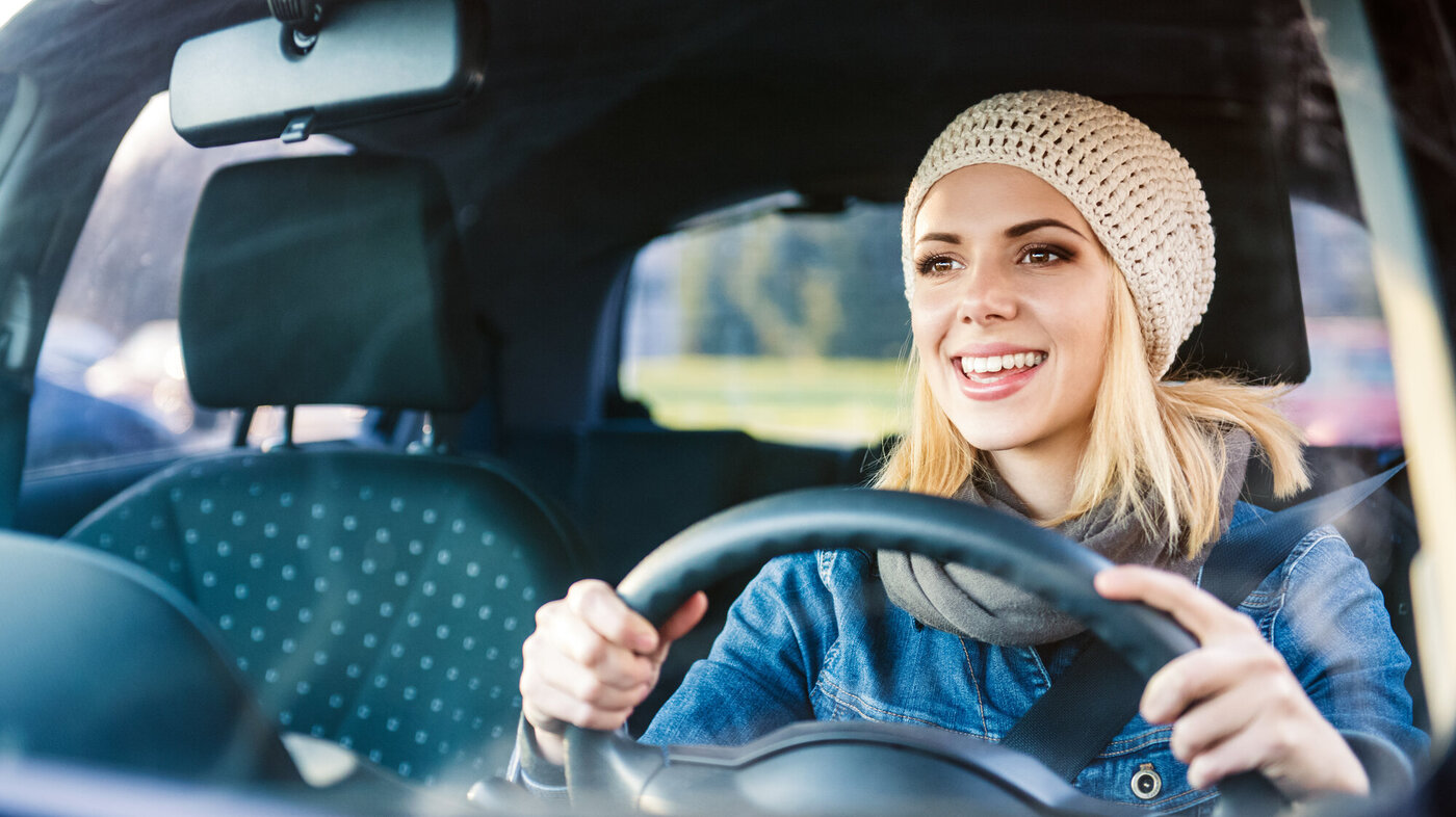Bildet viser ung kvinne som kjører bil