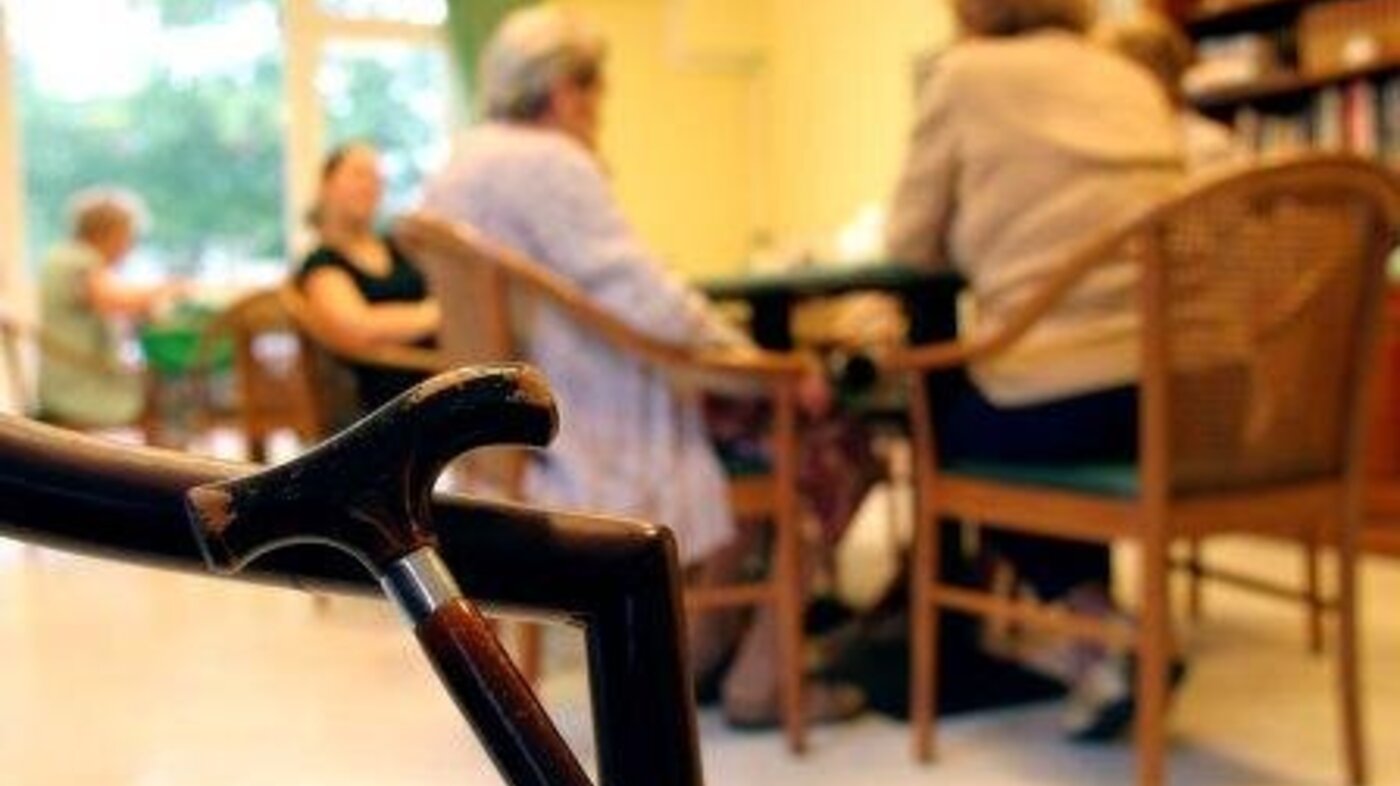 Fire sykehjem i Oslo blir nå helsehus forbeholdt korttidsopphold og rehabilitering. Bildet viser et stokkhåndtak med mennesker ute av fokus i bakgrunnen.