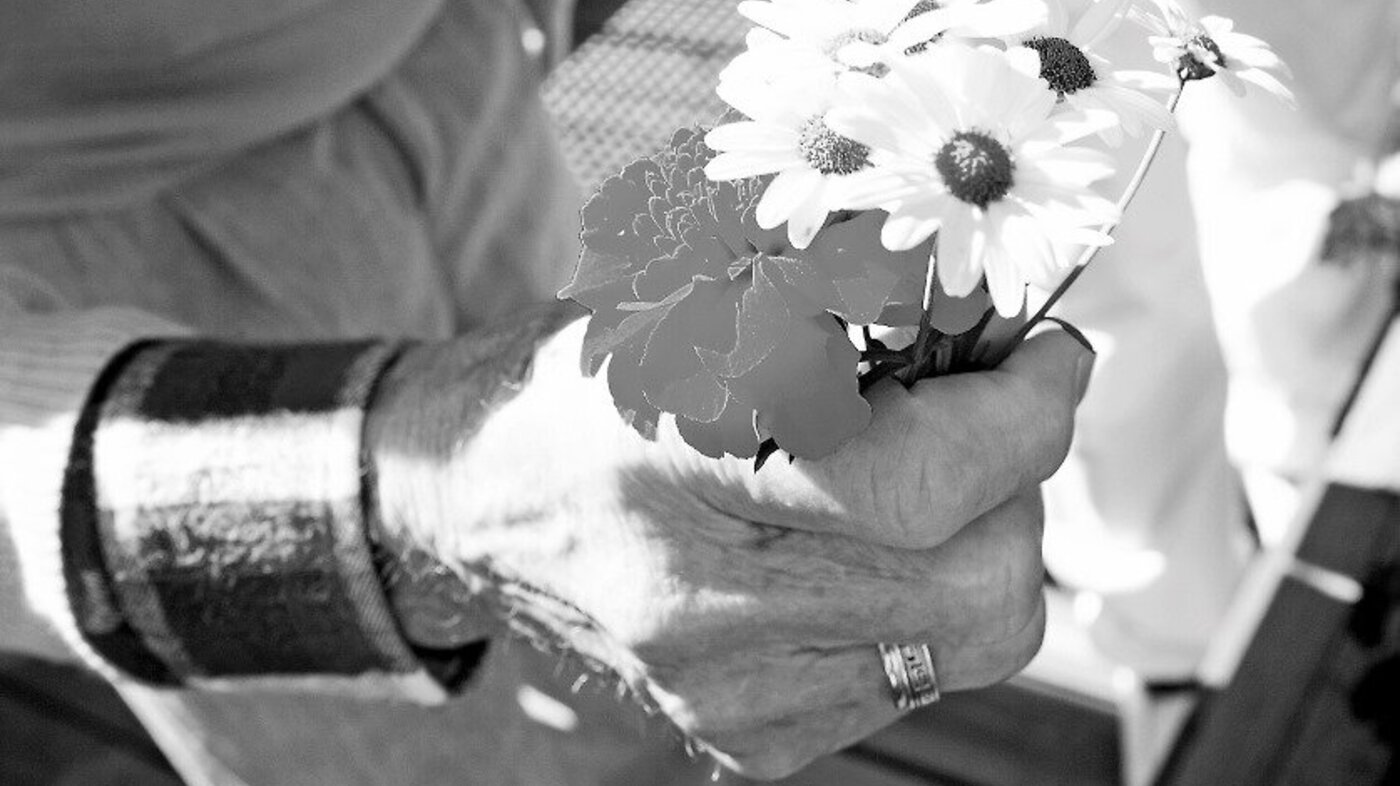 Eldre kvinne, blomsterbukett Eldre kvinne holder en blomsterbukett