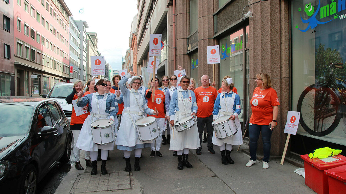 Streikende sykepleiere sammen med NSFs trommekorps utenfor Kreftforeningens lokaler i Oslo.