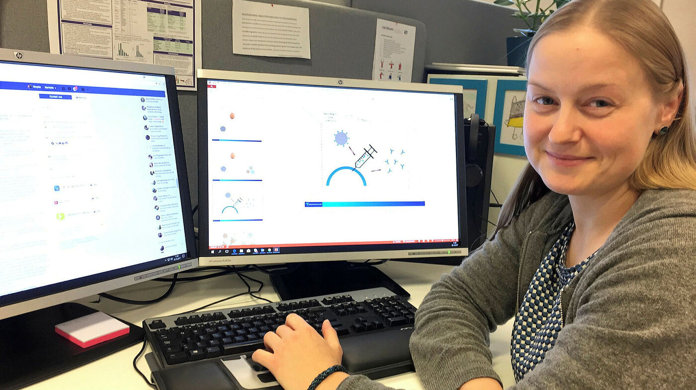 Bildet viser Birgitte Klüwer som sitter foran en datamaskin der skjermbildet viser illustrasjoner på influensavaksine.
