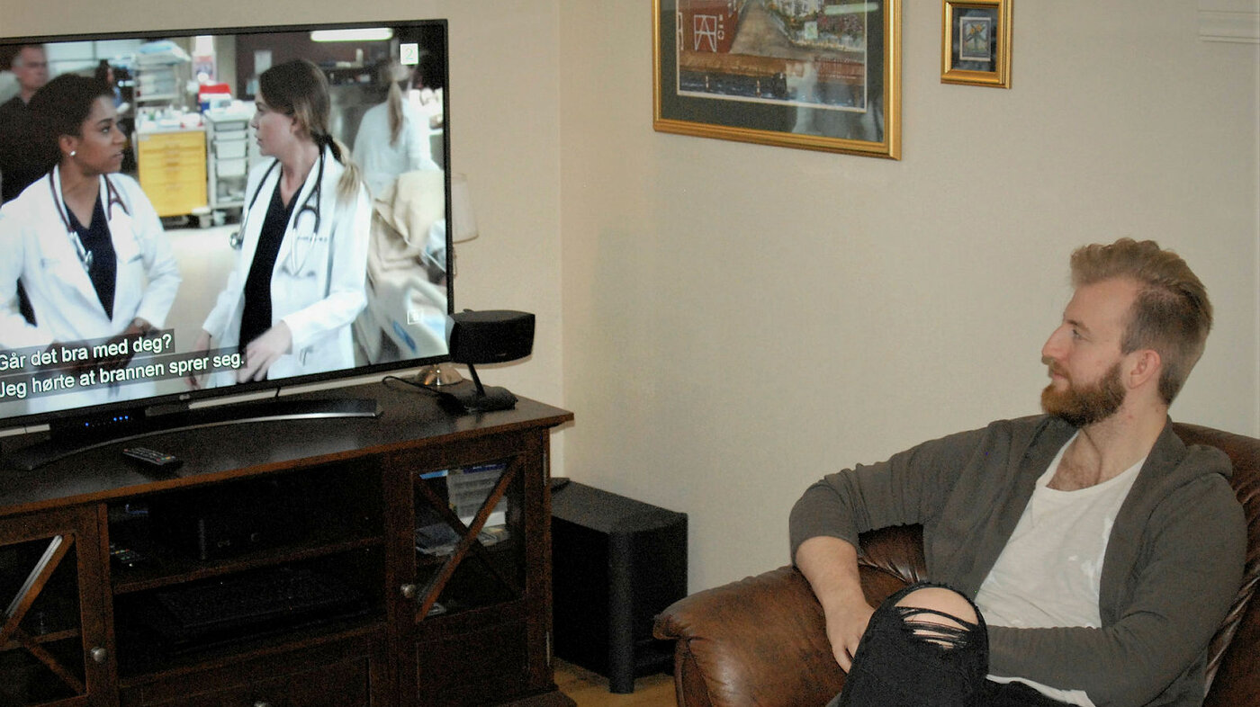 Sykepleier og tv-titter Josten Jørgensen i sofaen foran en episode av "Grey's Anatomy".