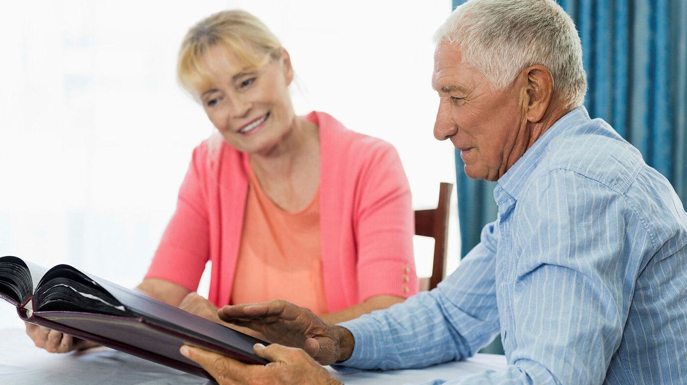 Senior couple looking at photo album in a retirement home