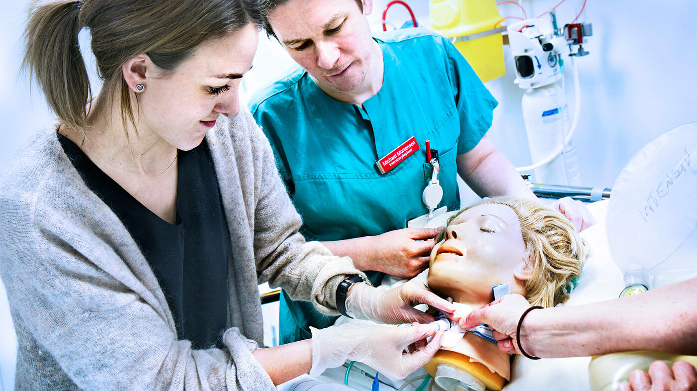 Bildet viser sykepleiere som øver på trakeostomi på en simuleringsdukke.