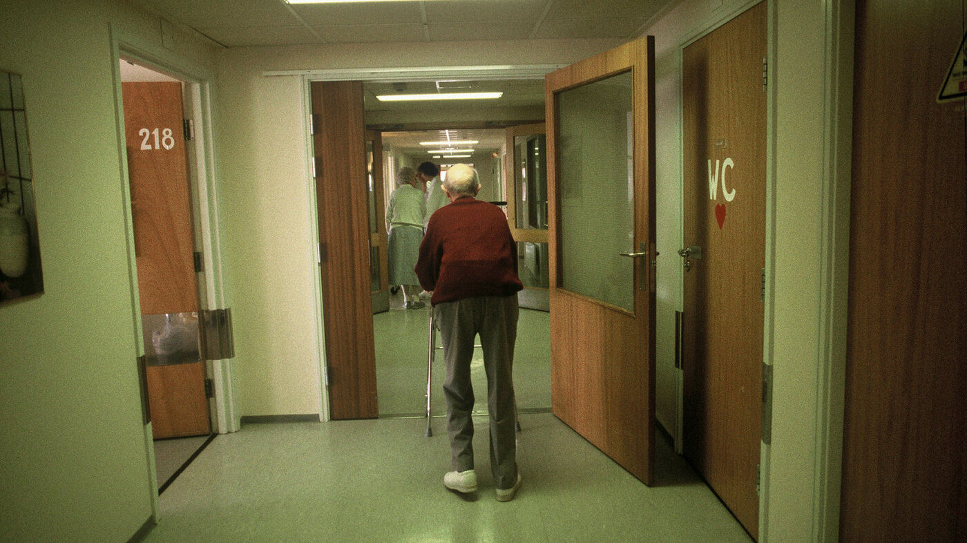 Eldre mann i sykehjemskorridor