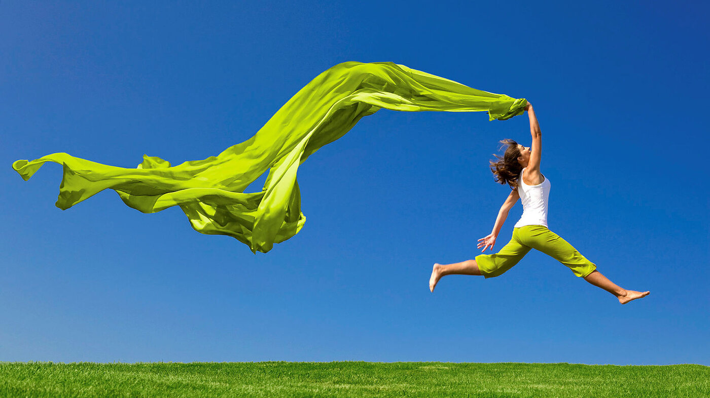 Bildet viser en kvinne som svever gjennom luften med et flagrende tøystykke etter seg