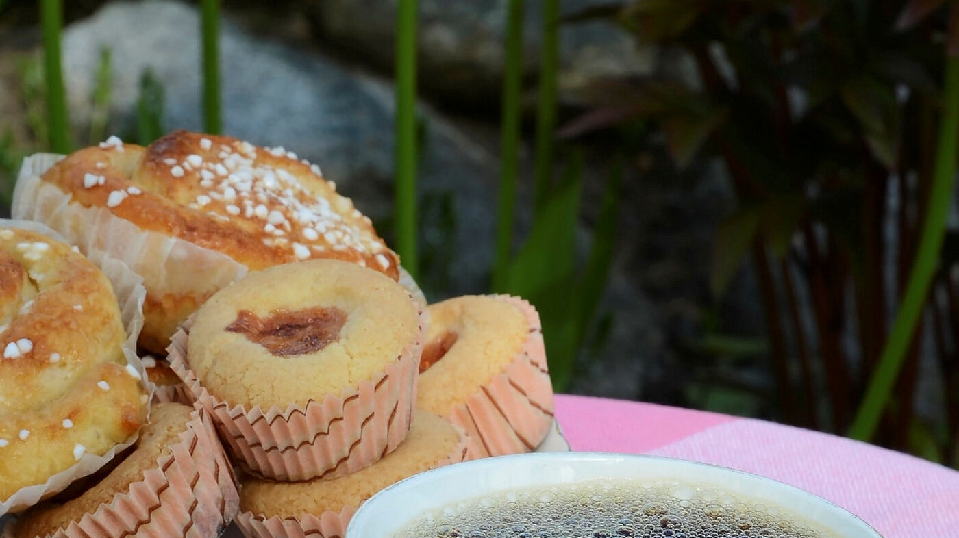 Kaffekopp og muffins på et bord med duk.