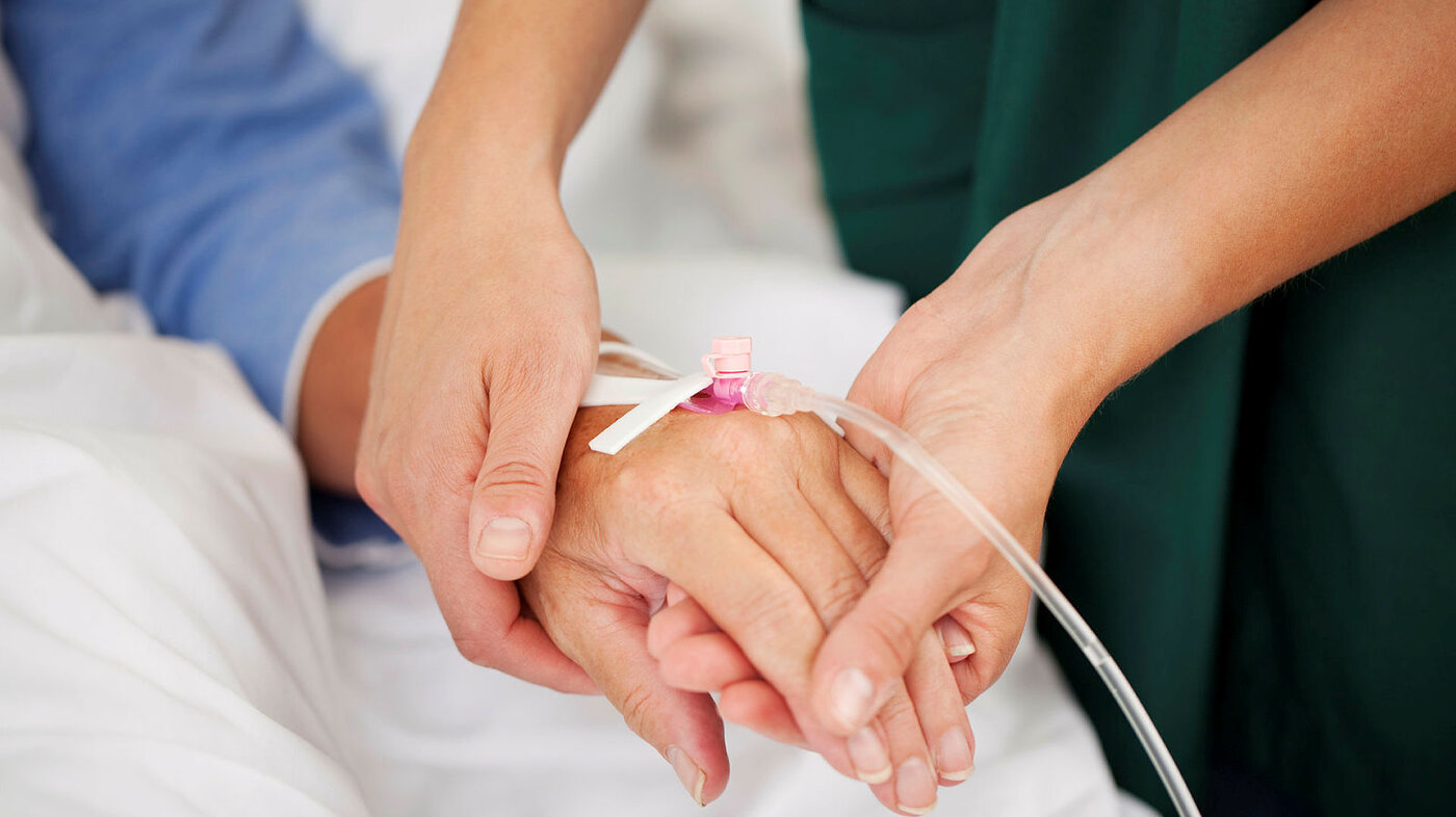 Sykepleier holder pasienthånd