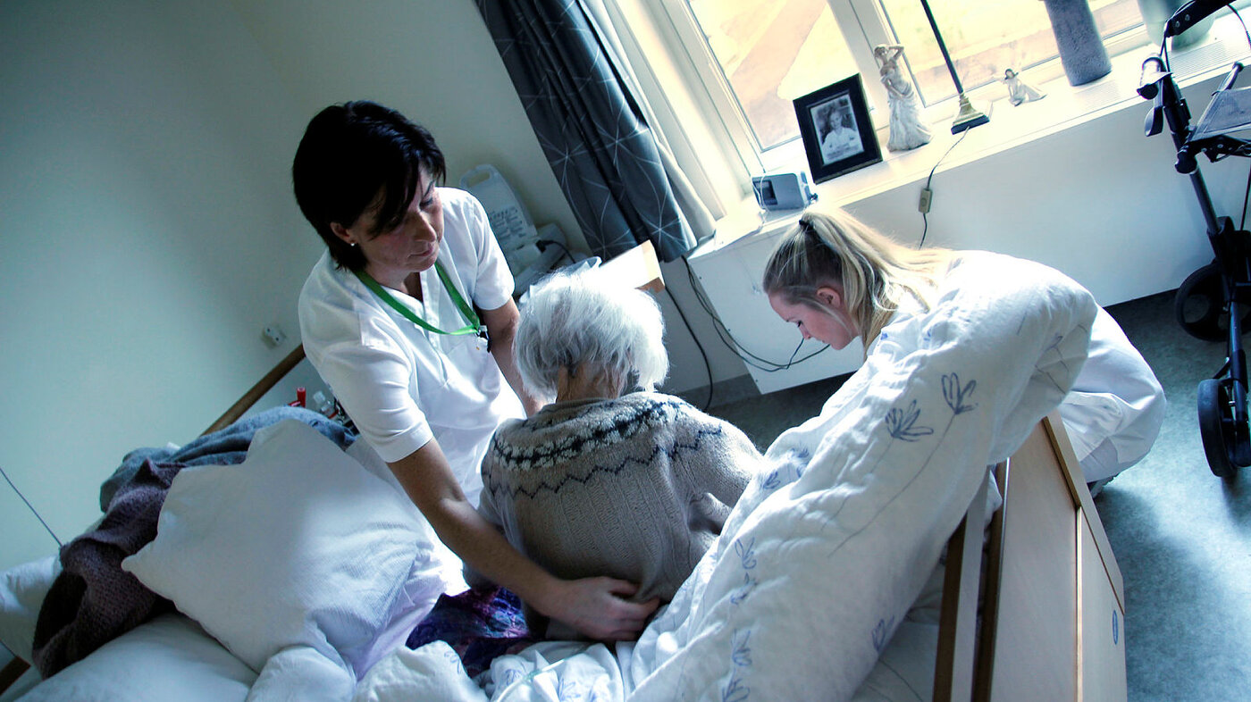 to sykepleiere hjelper en pasient ved sykehjemmet på Karmøy
