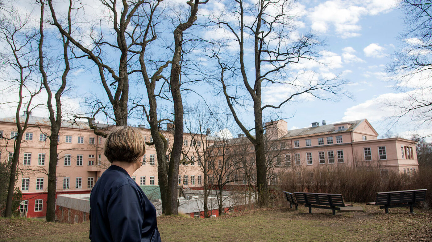 Bildet viser Karin Jonli som står med ryggen til og ser mot bygningen der Sophies Minde lå tidligere.