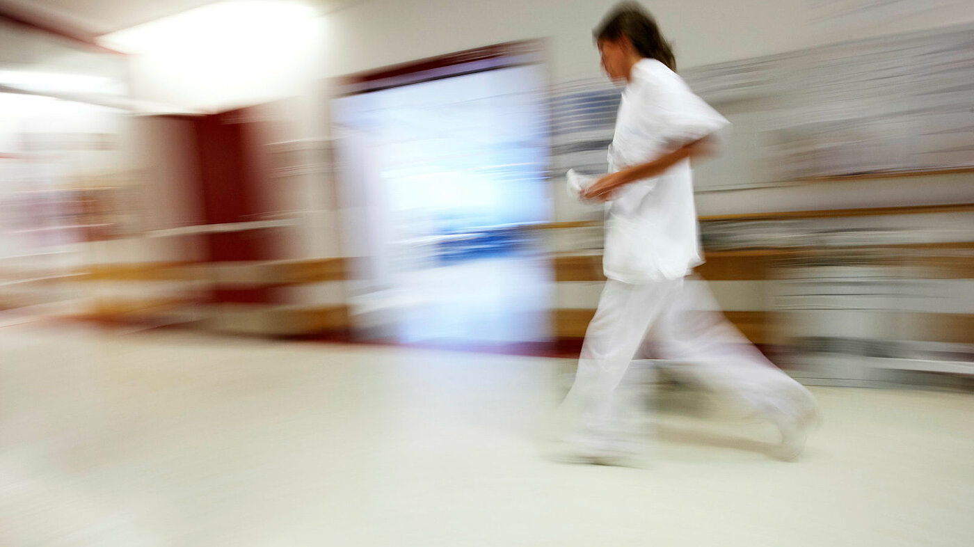 Sykepleier som løper og stresser.